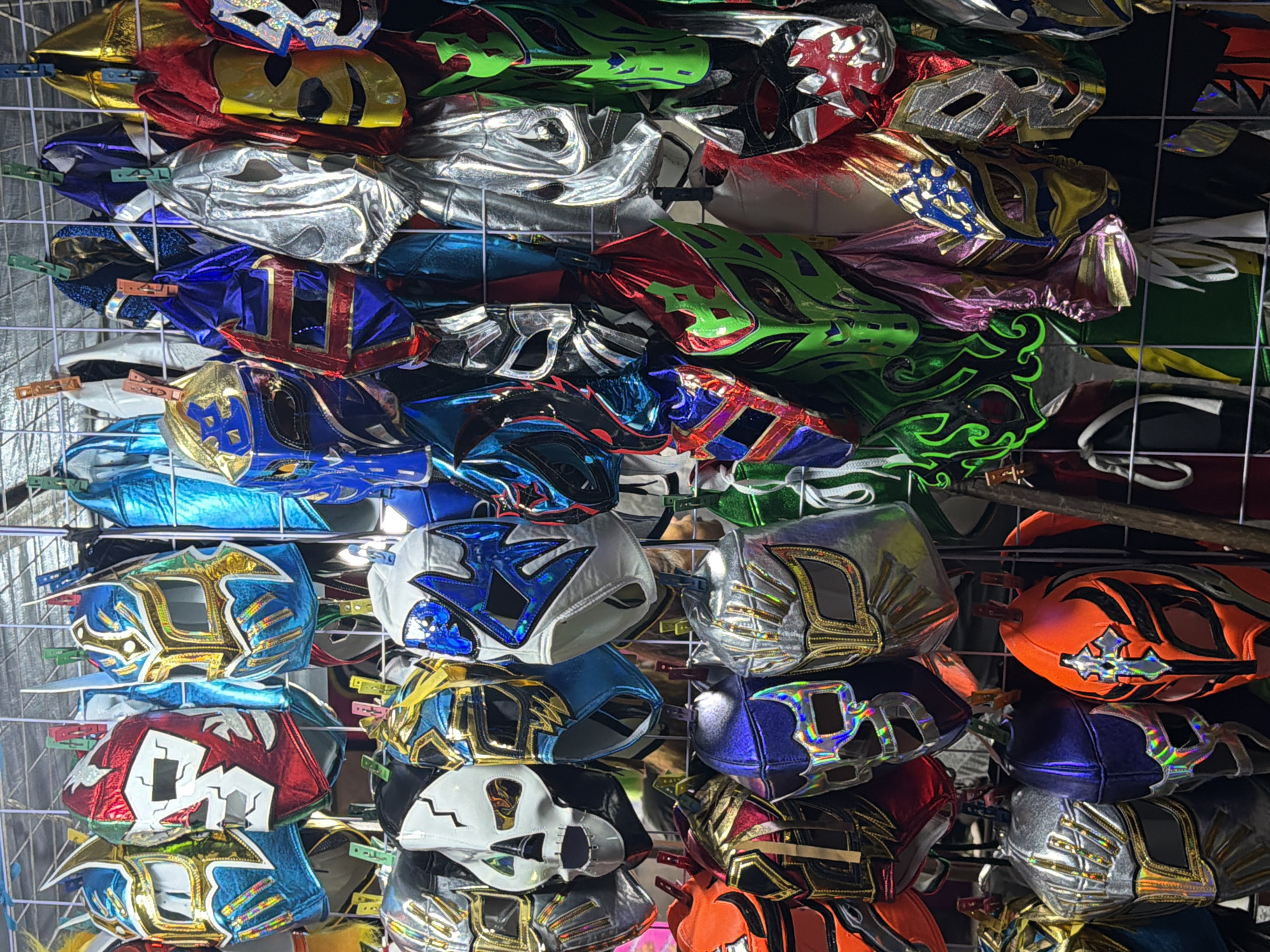 Lucha Libre masks displayed on wire rack in Puebla