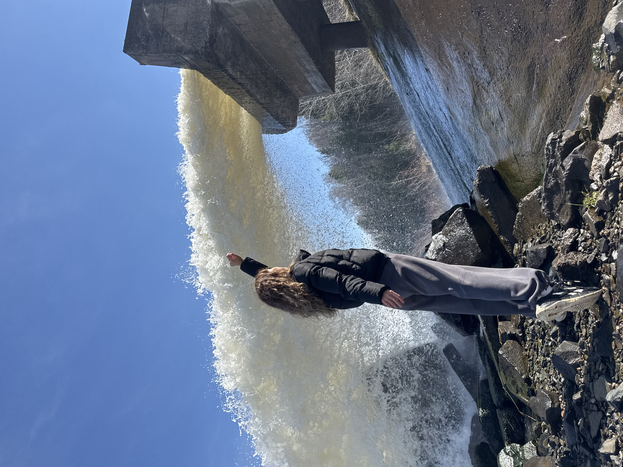 Person poses at waterfall base in Noviy, Russia