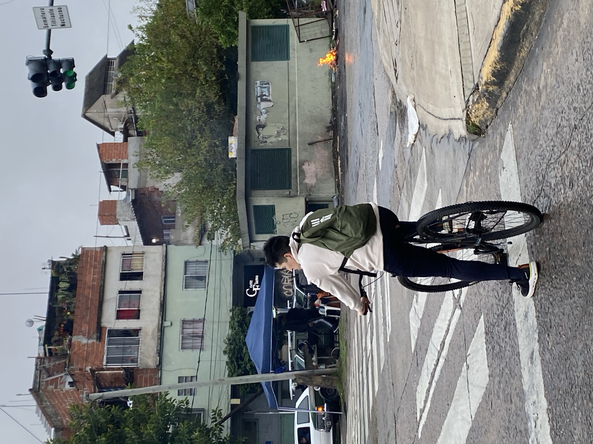 Cyclist rides on wet Buenos Aires street after rain