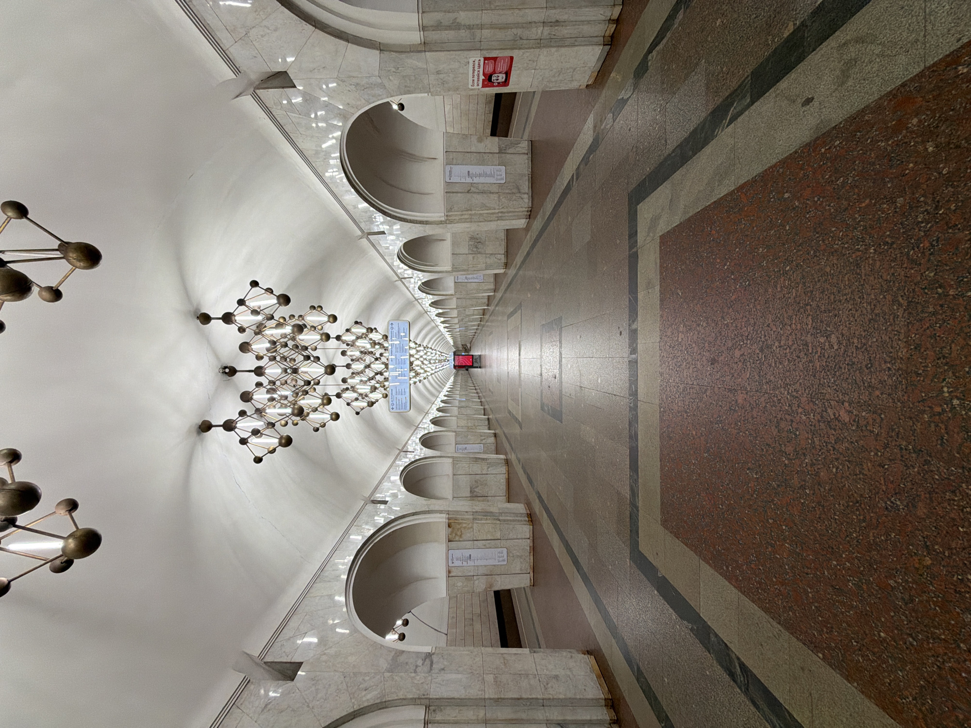 Ornate subway station hall with bronze chandeliers documented
