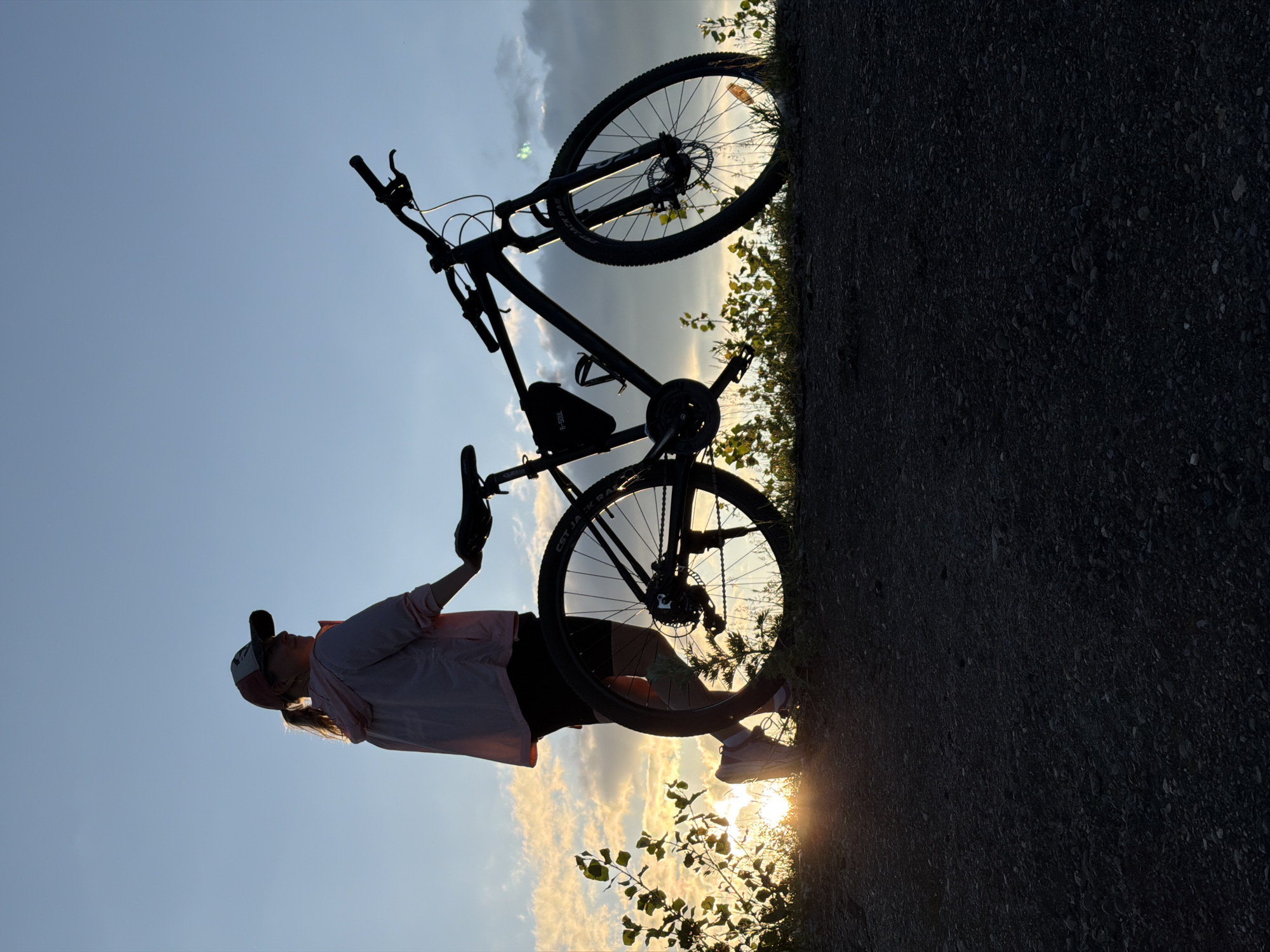 Cyclist pauses for sunset along Kama River in Russia