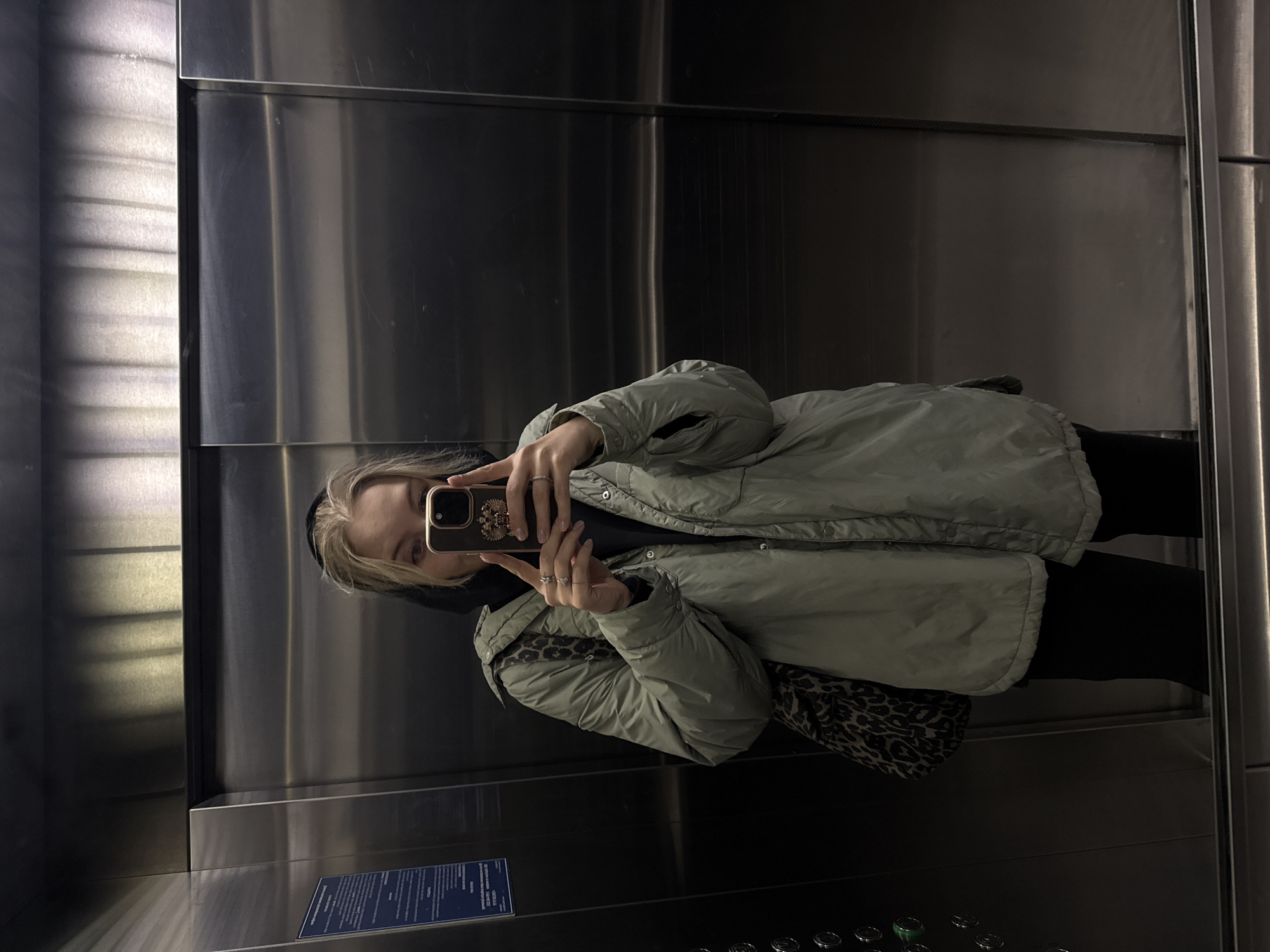 Person takes sideways mirror selfie in Krasnoyarsk elevator
