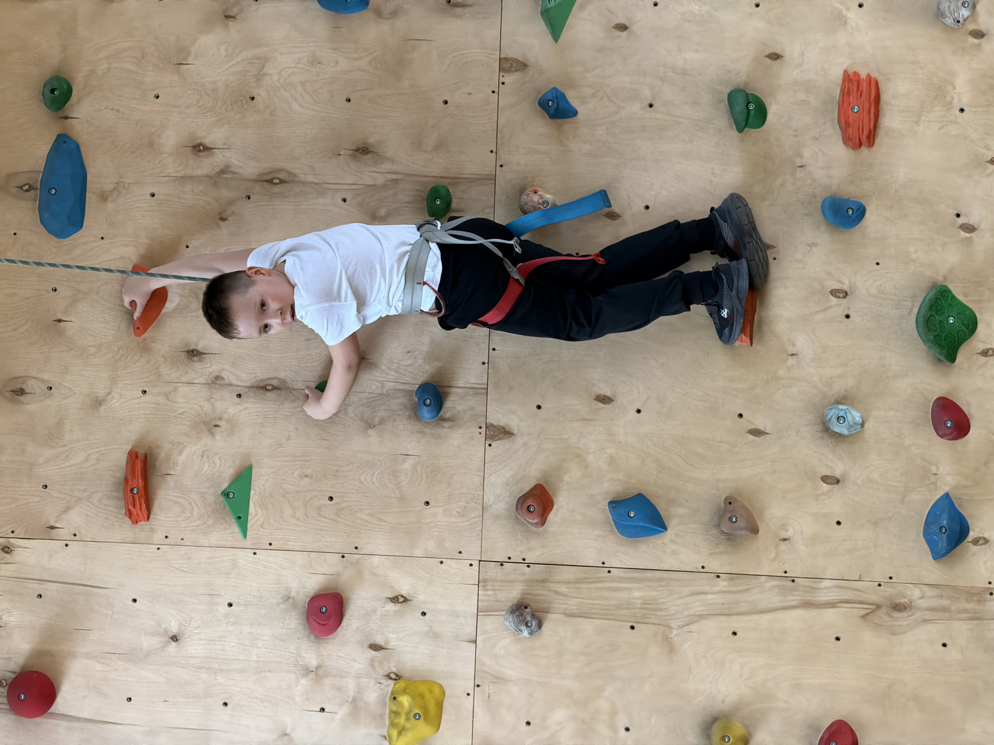 Young girl rock climbing at indoor facility in Izhevsk