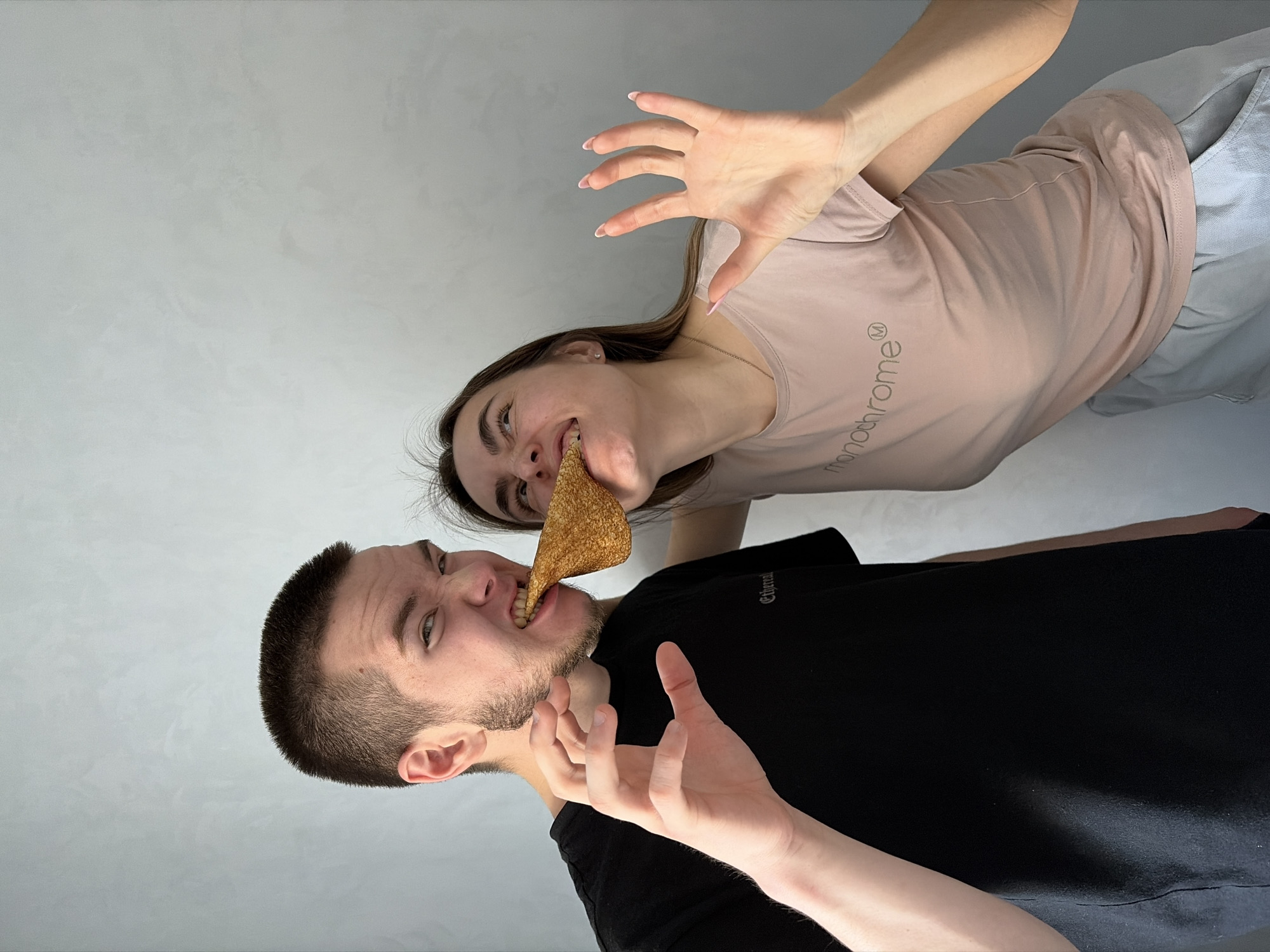Couple shares food, man poses with fruit indoors