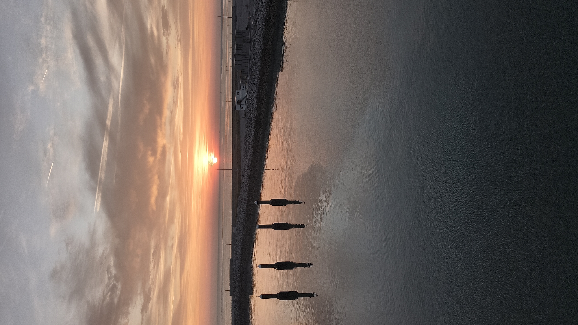 Sunrise over Calais harbor, warm light on still water
