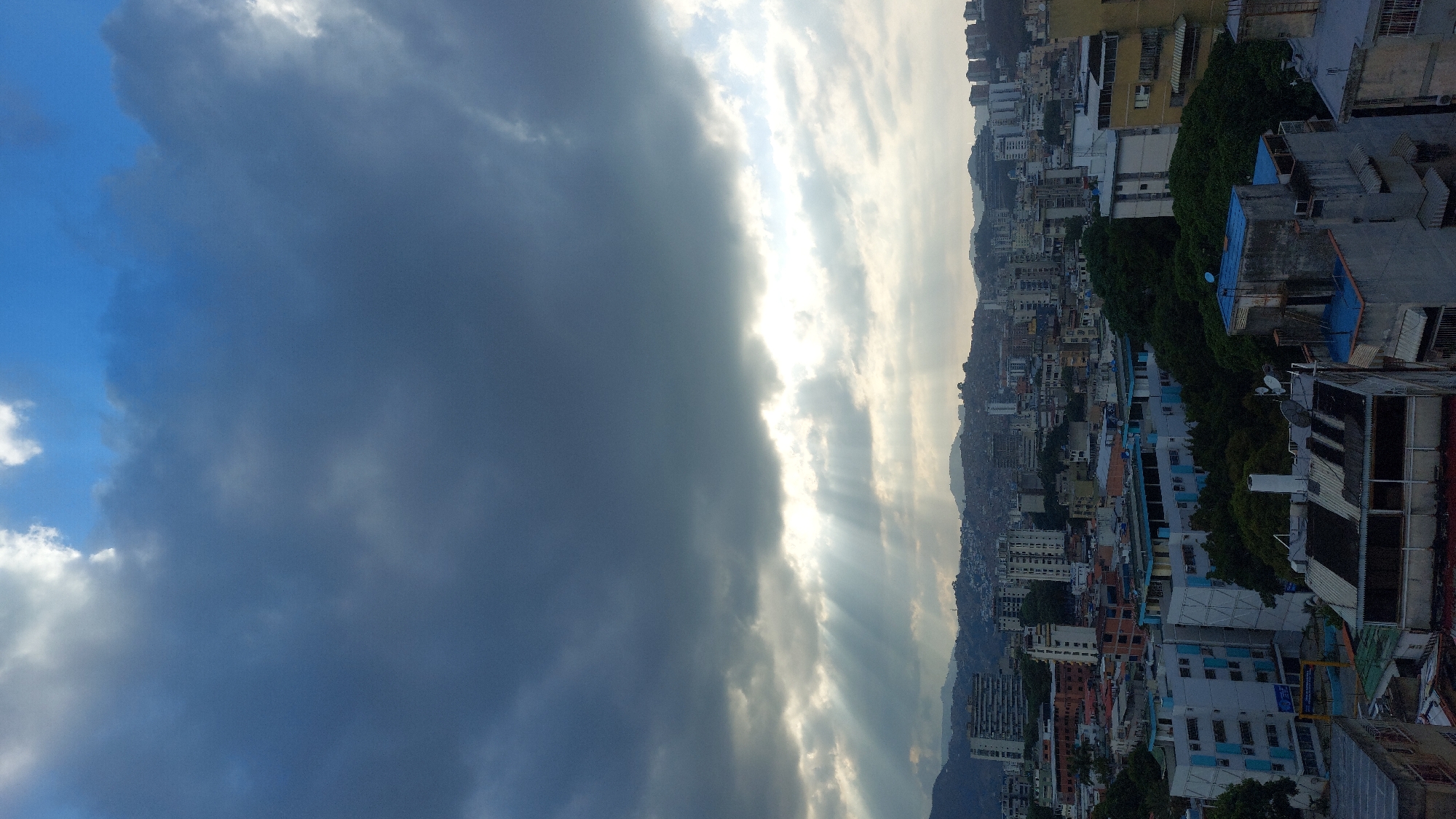 Dramatic storm clouds contrast with bright skies over Caracas