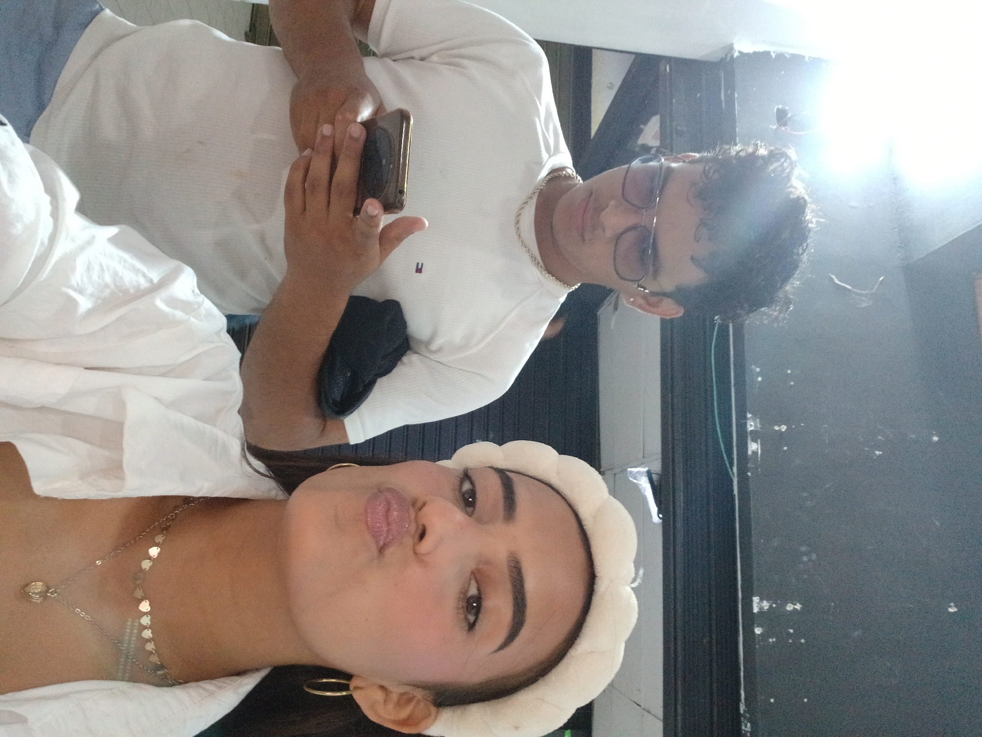Woman takes multiple selfies in white outfit in Porlamar