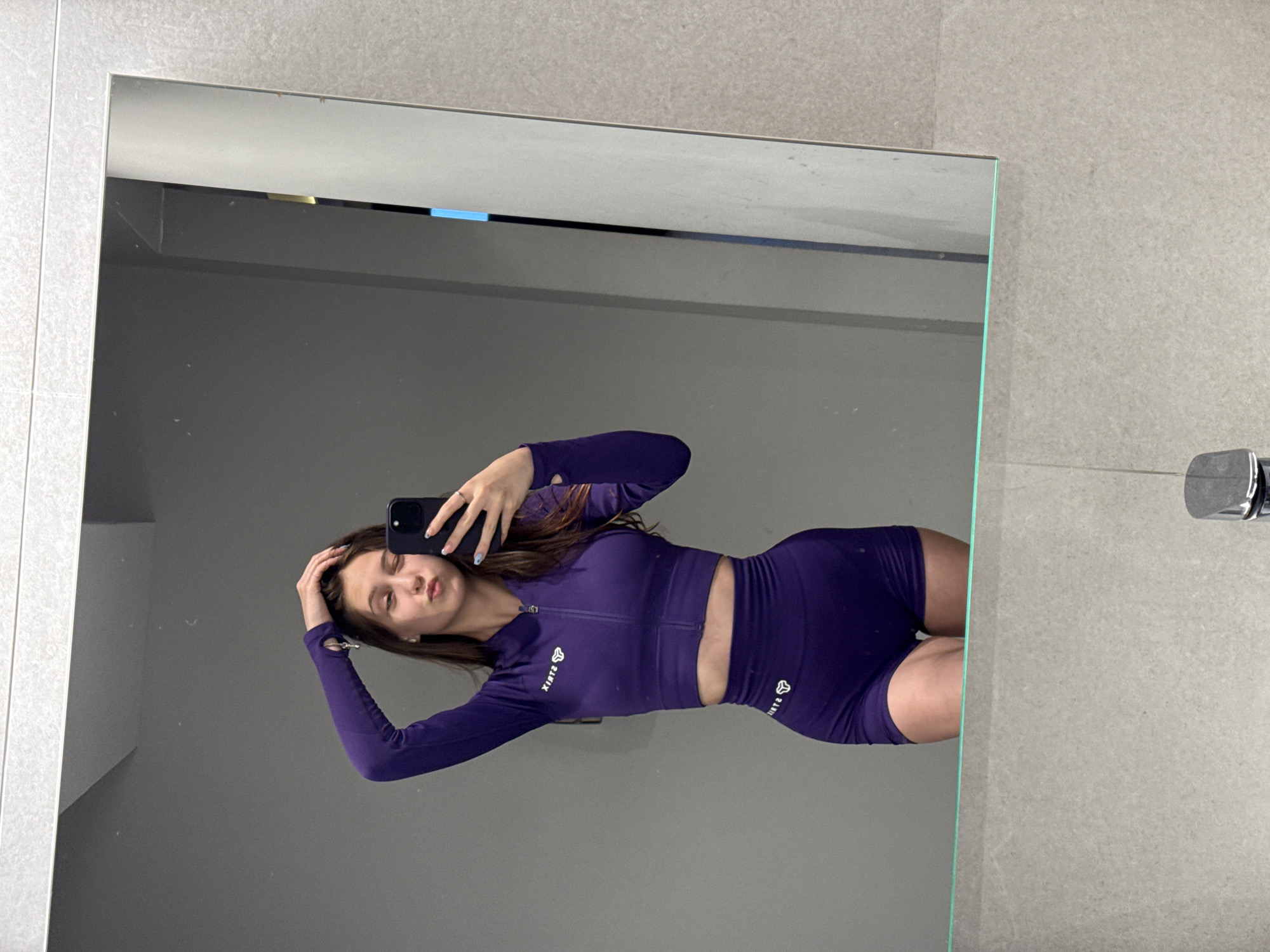 Woman takes mirror selfie in purple workout outfit, Sofia