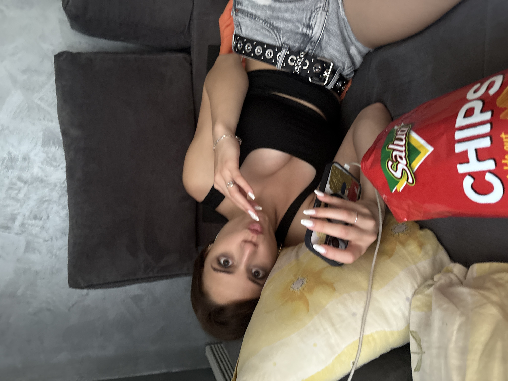 Woman relaxes on couch with snacks in Pernik, Bulgaria
