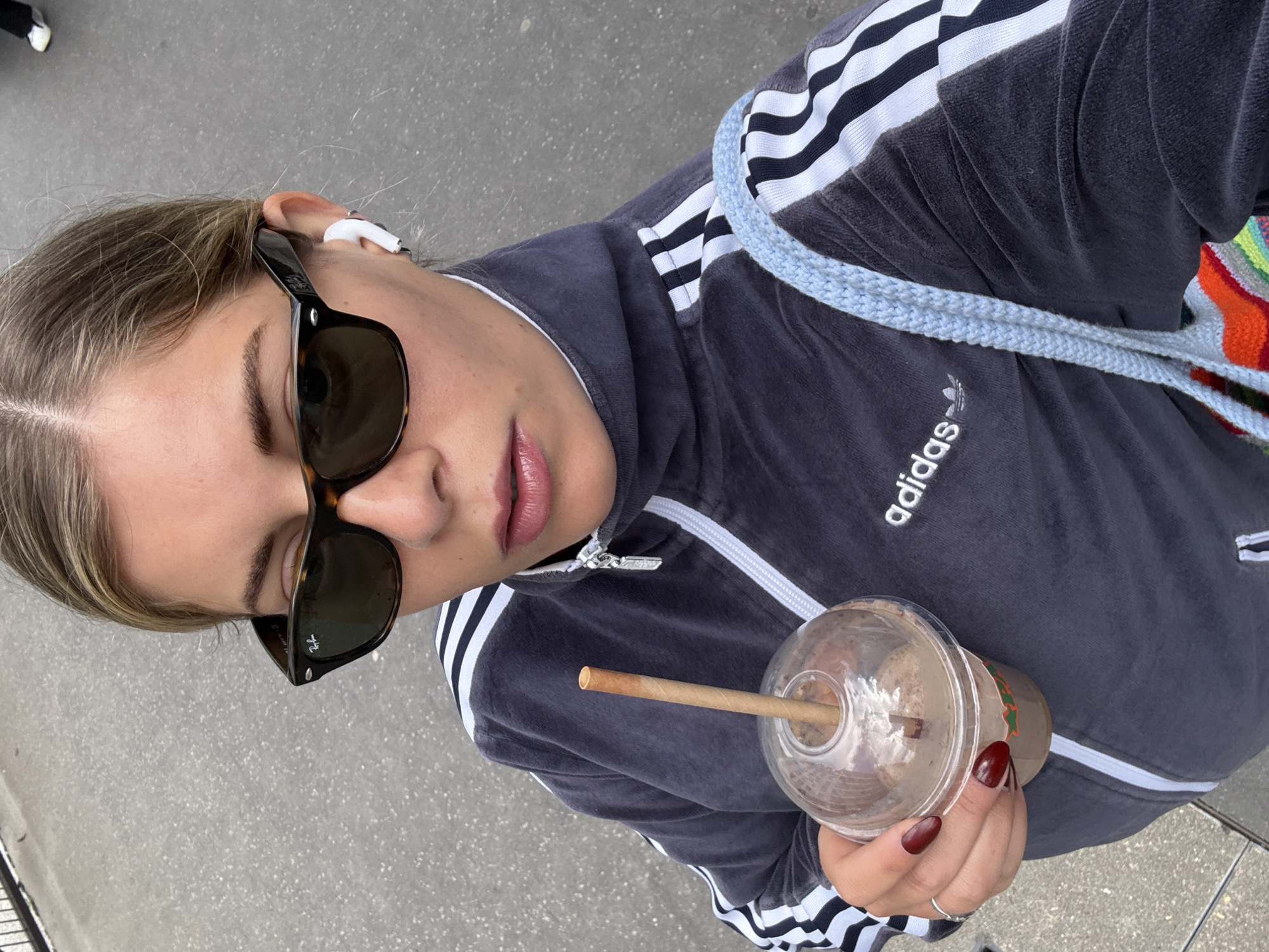 Woman takes selfie while drinking on Paris street