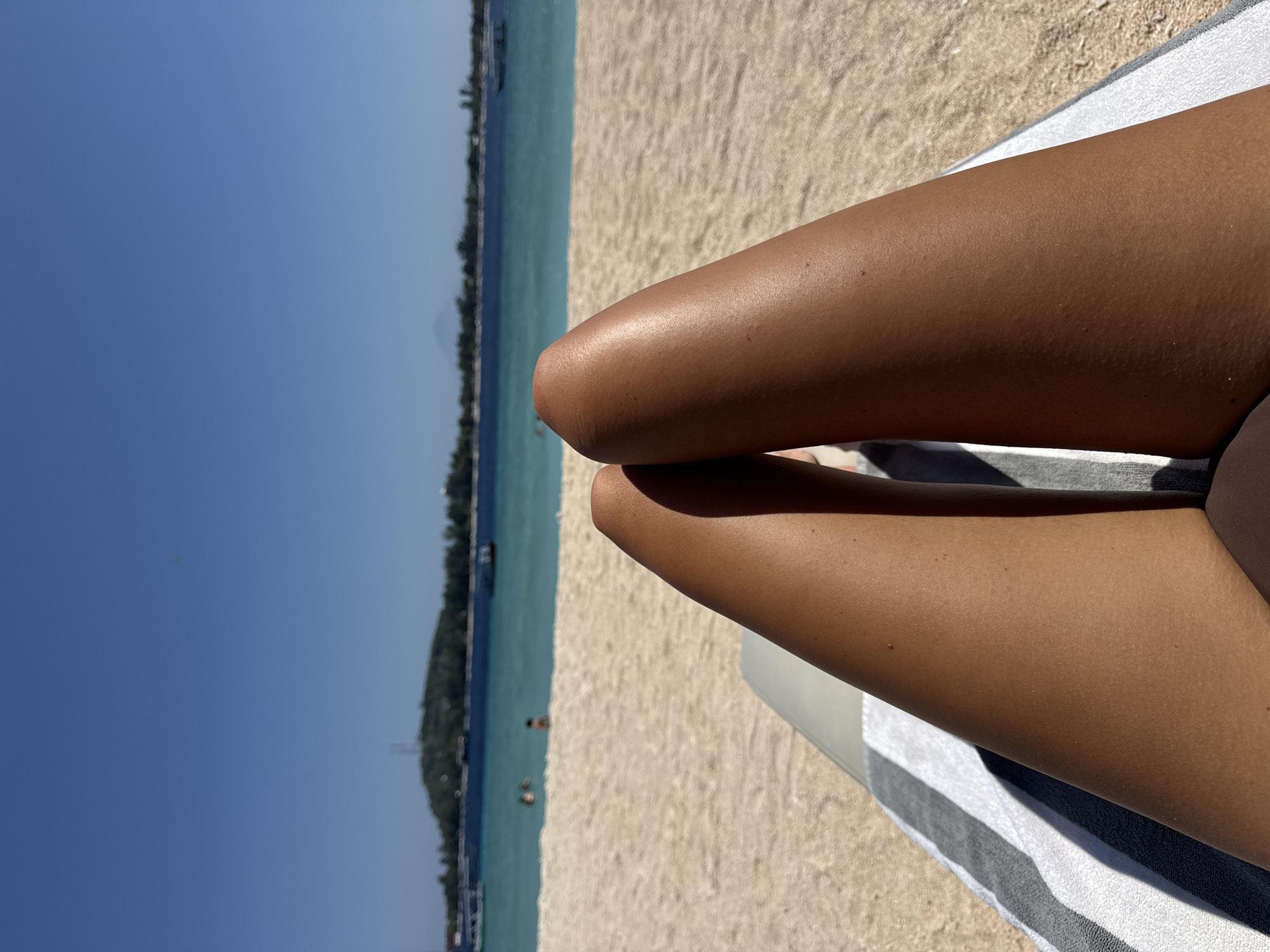 Woman sunbathes on striped towel at Indonesian beach