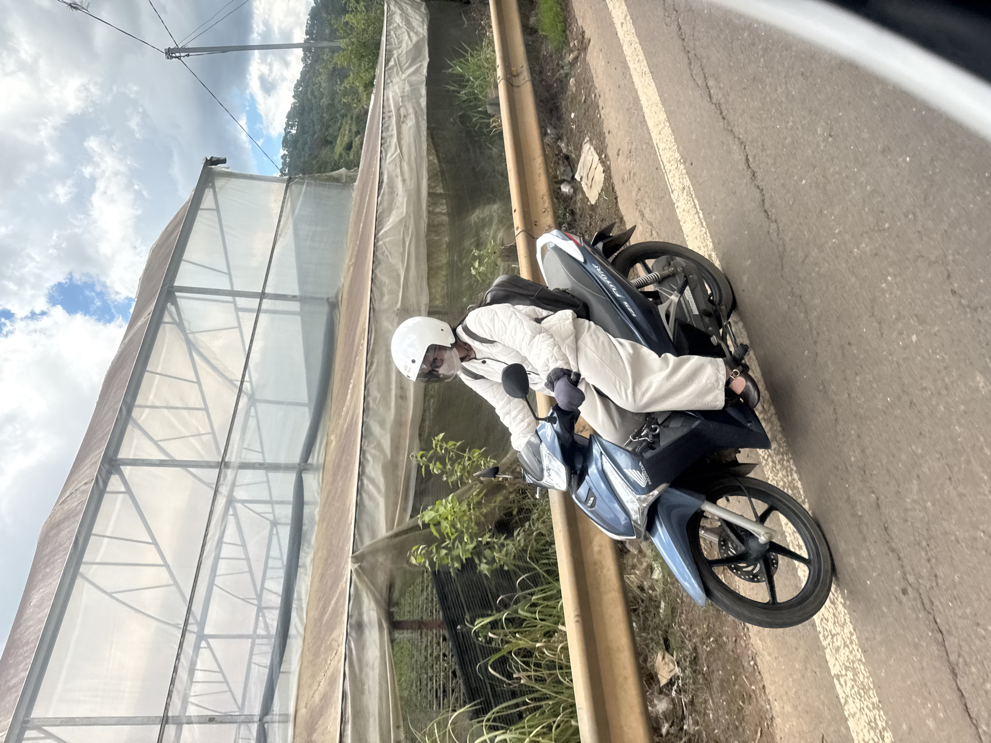 Motorcycle with backpack moves through Đạ Cháy at dawn