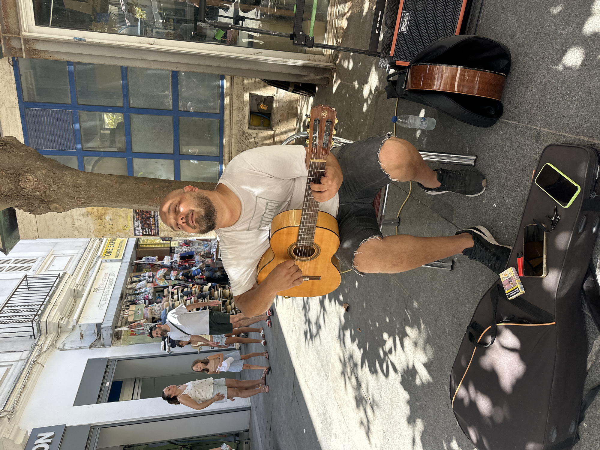 Acoustic guitar duo plays a sunny sidewalk session in Cádiz