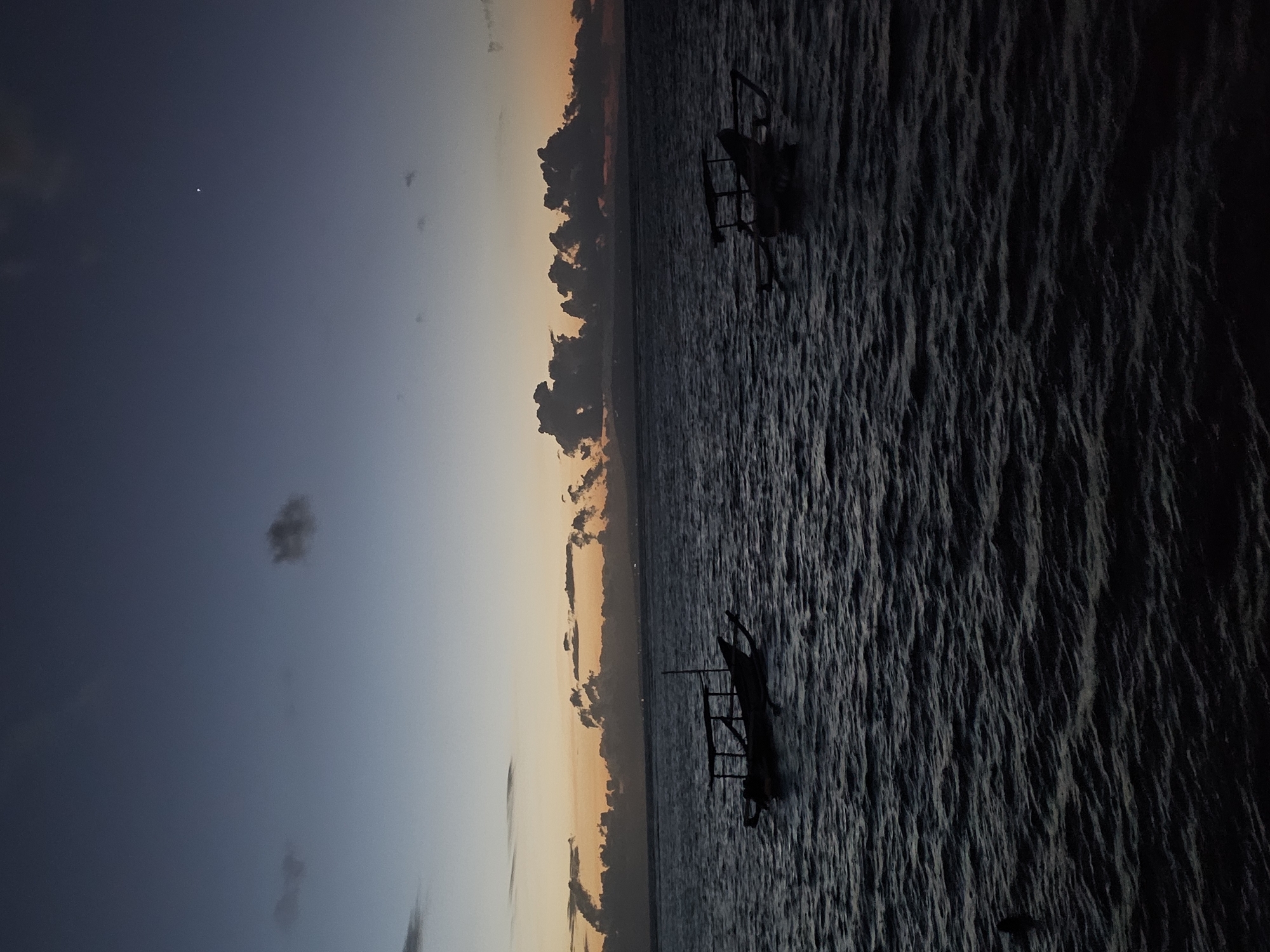 Sanur Beach at dusk — boats, promenades, and waterfront dining