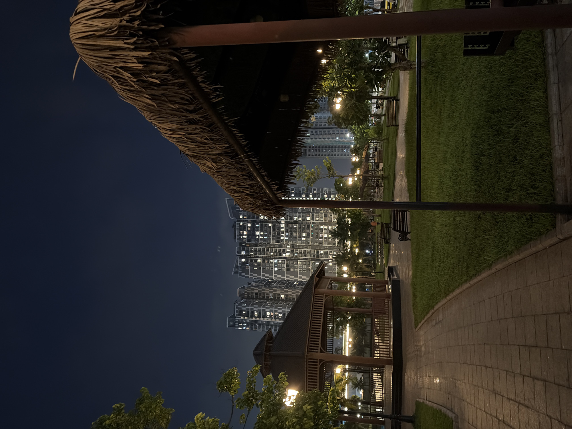 Nighttime hang at a Hanoi waterfront park beside rising towers