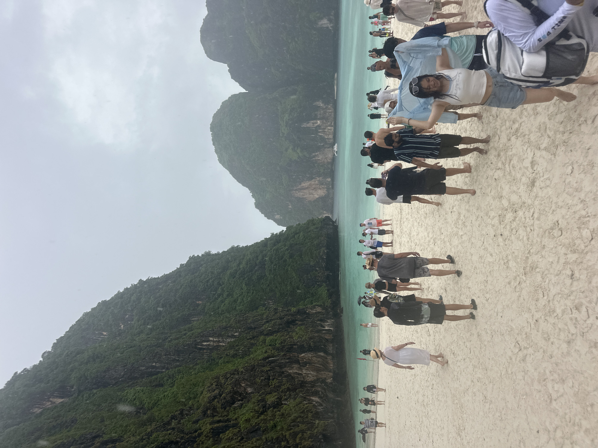 Rainy day at Ao Nang beach, karsts, warning flags, and wet trails