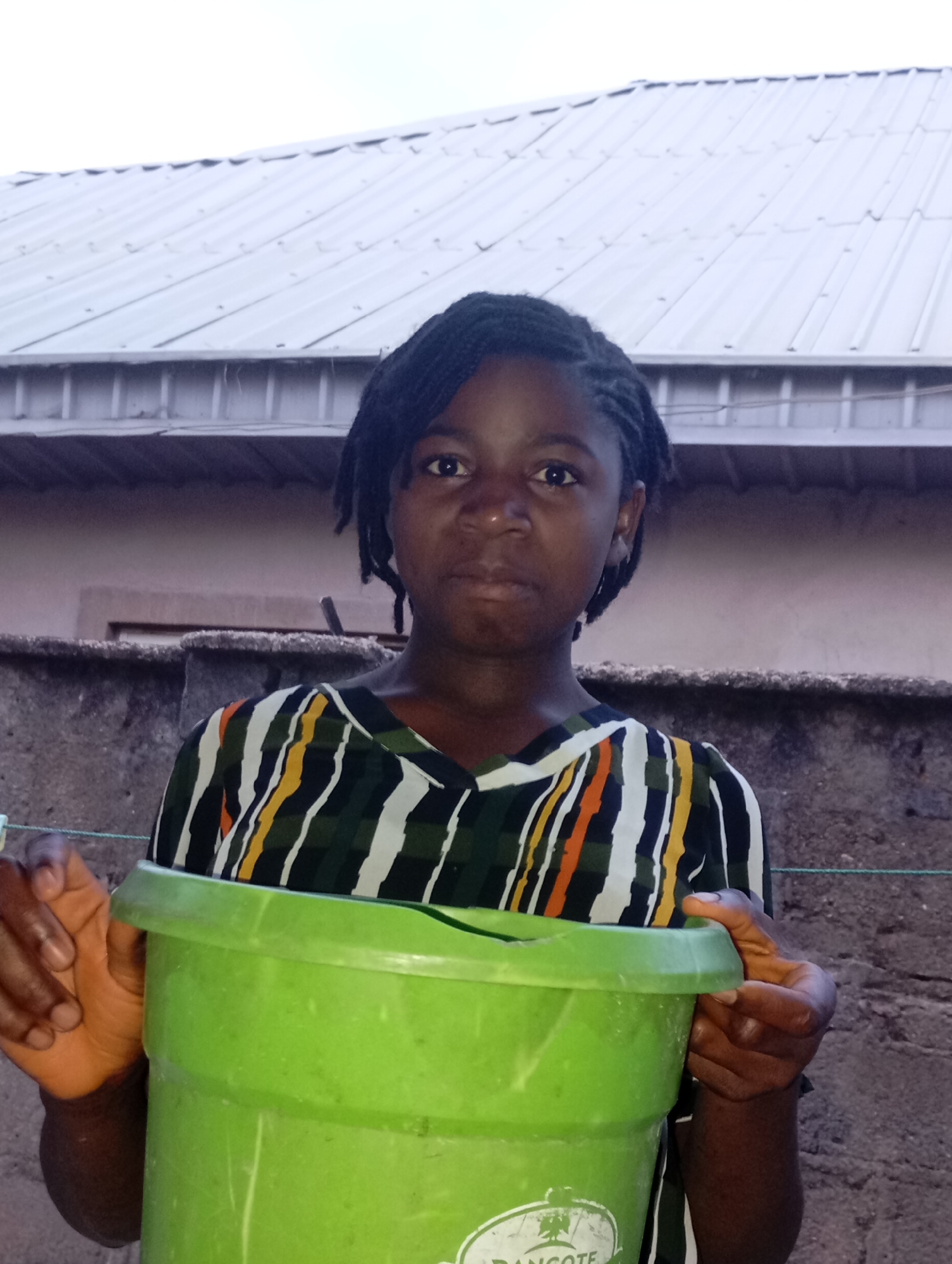 Young woman photographed with buckets in Jos residential area