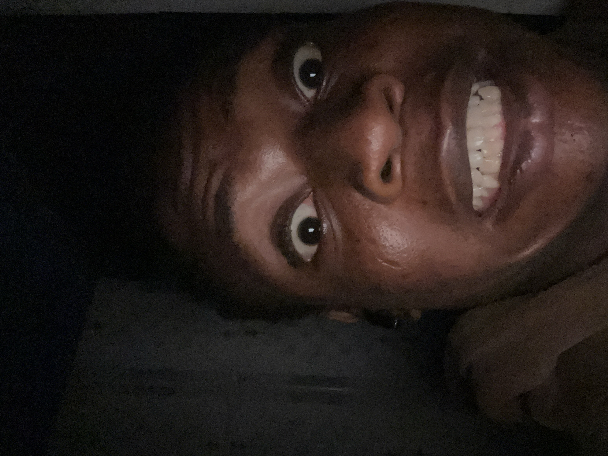 Person photographed making animated expressions during late-night session