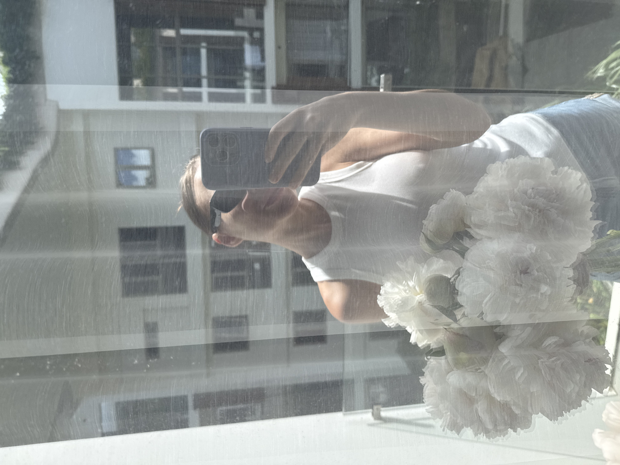 Woman with peony bouquet photographed taking selfie in Thailand