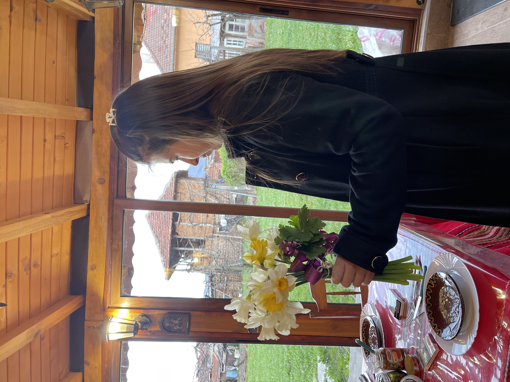 Person with crown holds spring bouquet in Varshets, Bulgaria