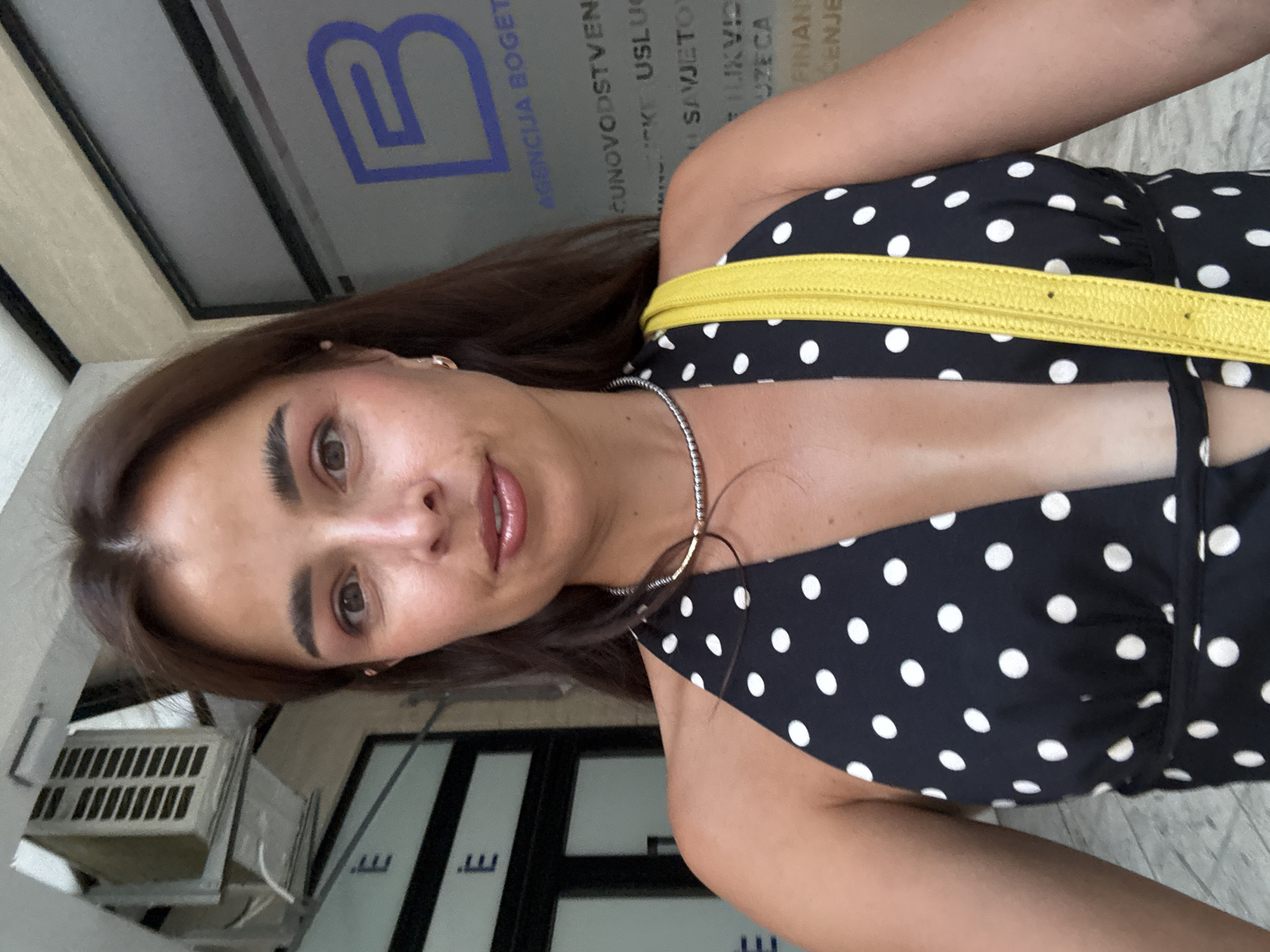 Afternoon moments in a tiled urban plaza, polka dots and yellow bag.