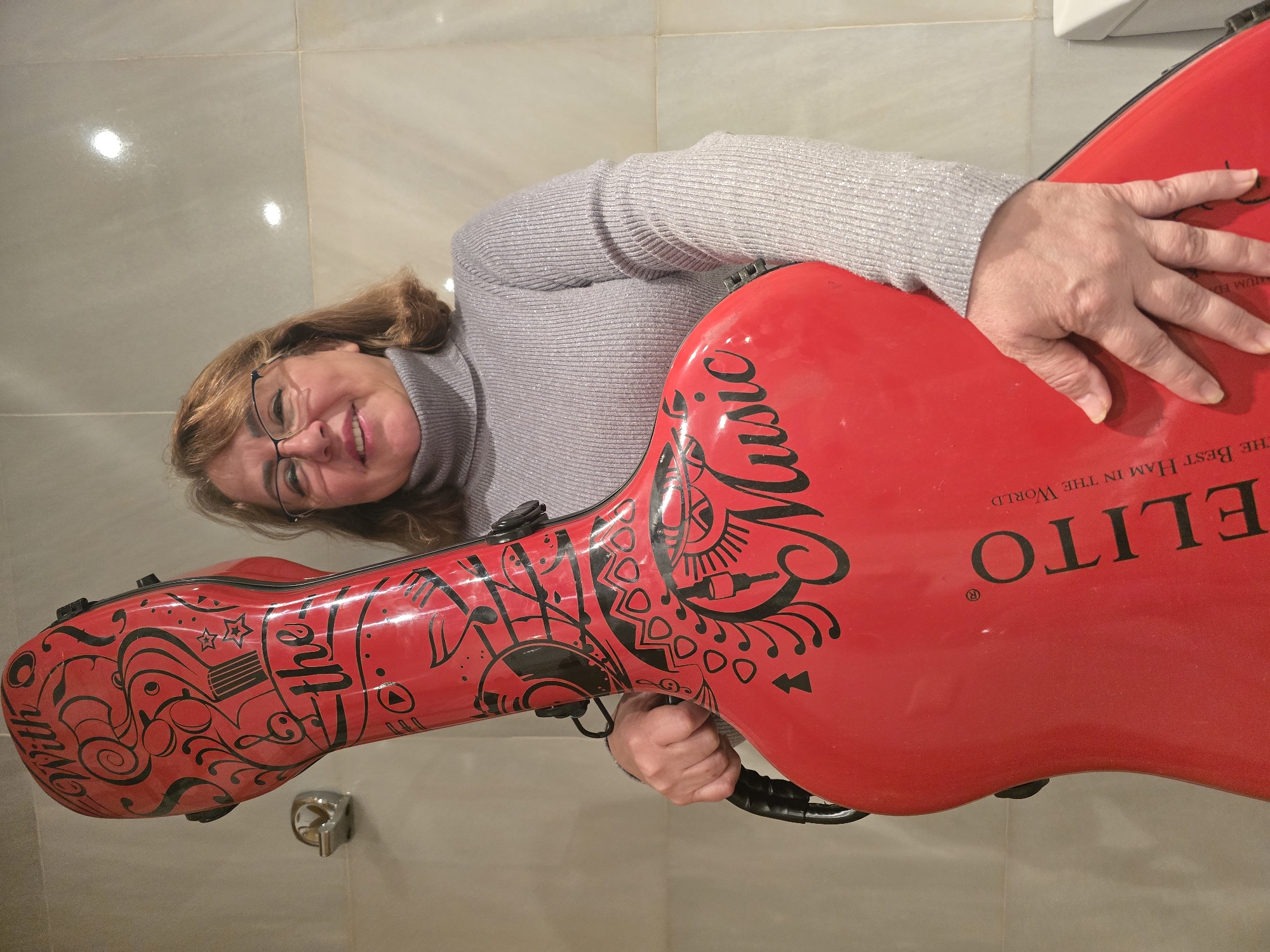 Woman poses with musical instrument case in Barcelona office