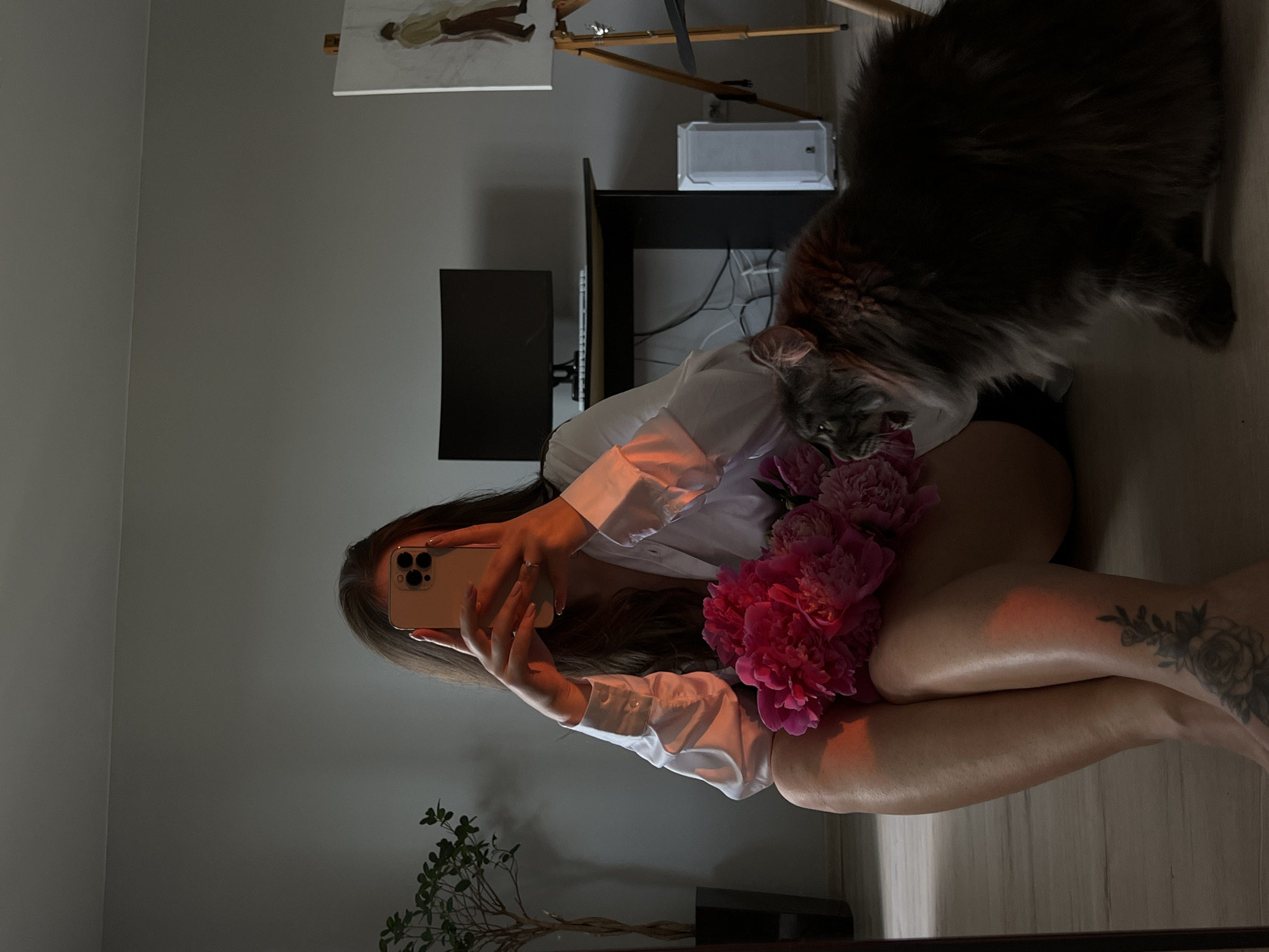 Woman takes selfies with pink peonies in Ternopil home