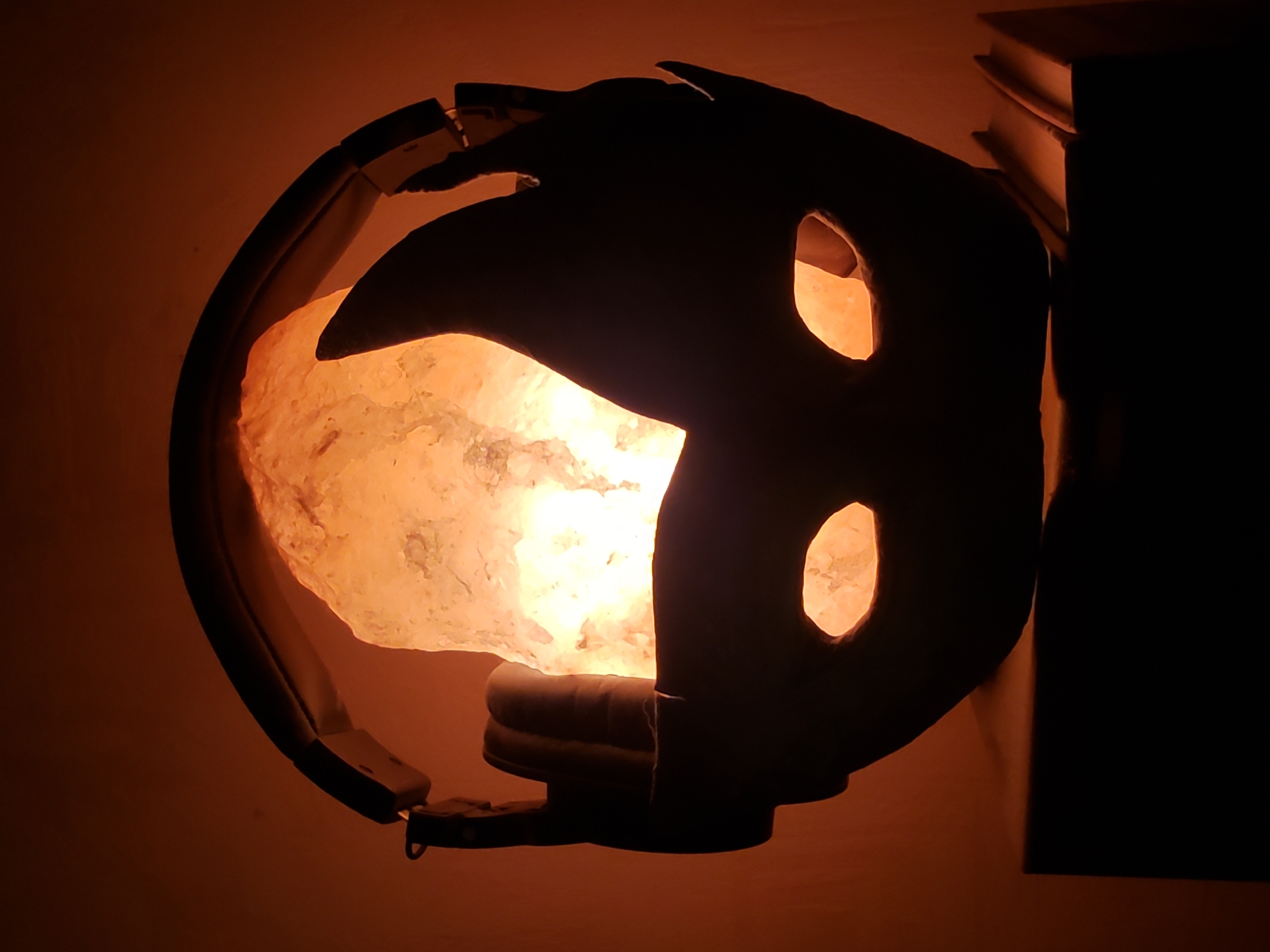 Salt lamp glowing beside headphones and a mask