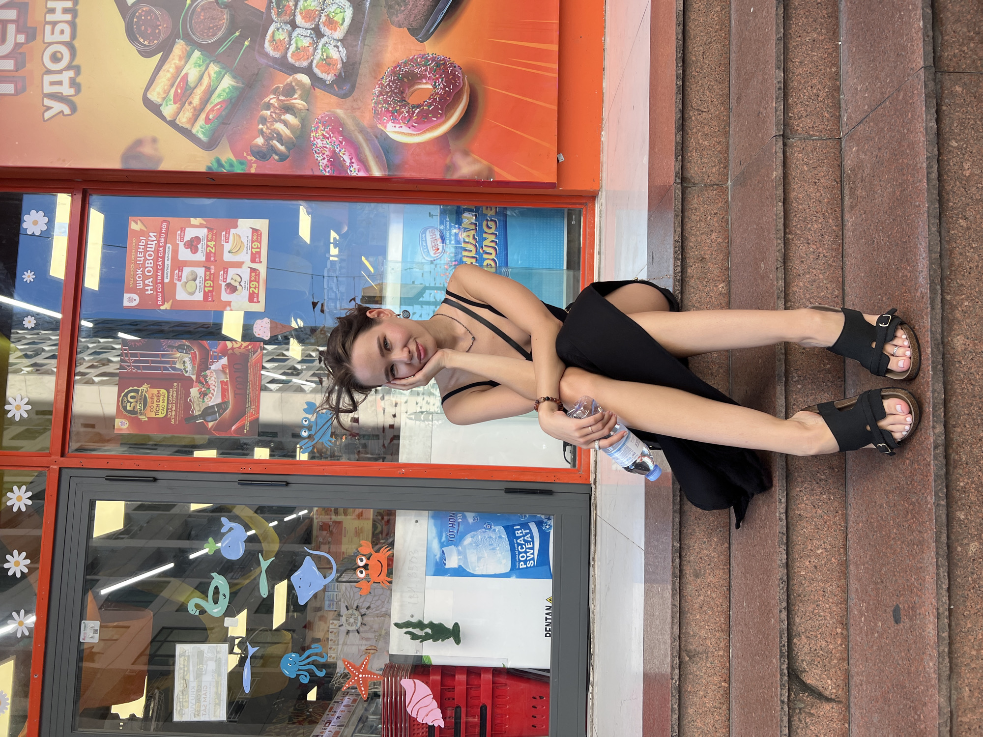 Woman sits peacefully on store steps in Vietnam