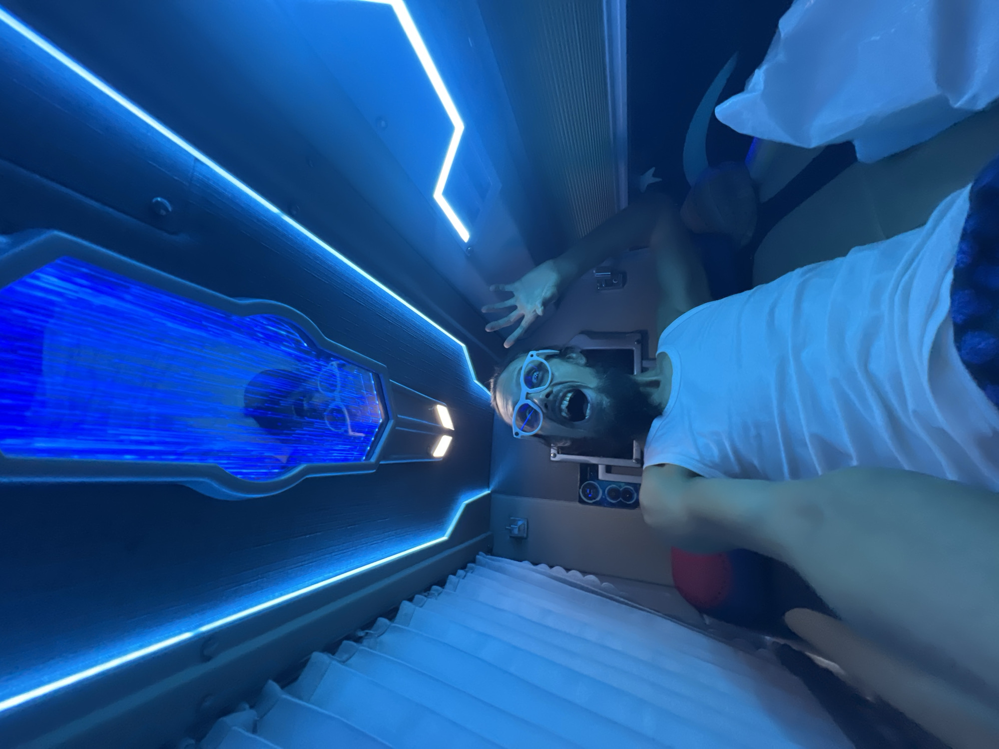 Selfie clips inside a neon-lit capsule pod