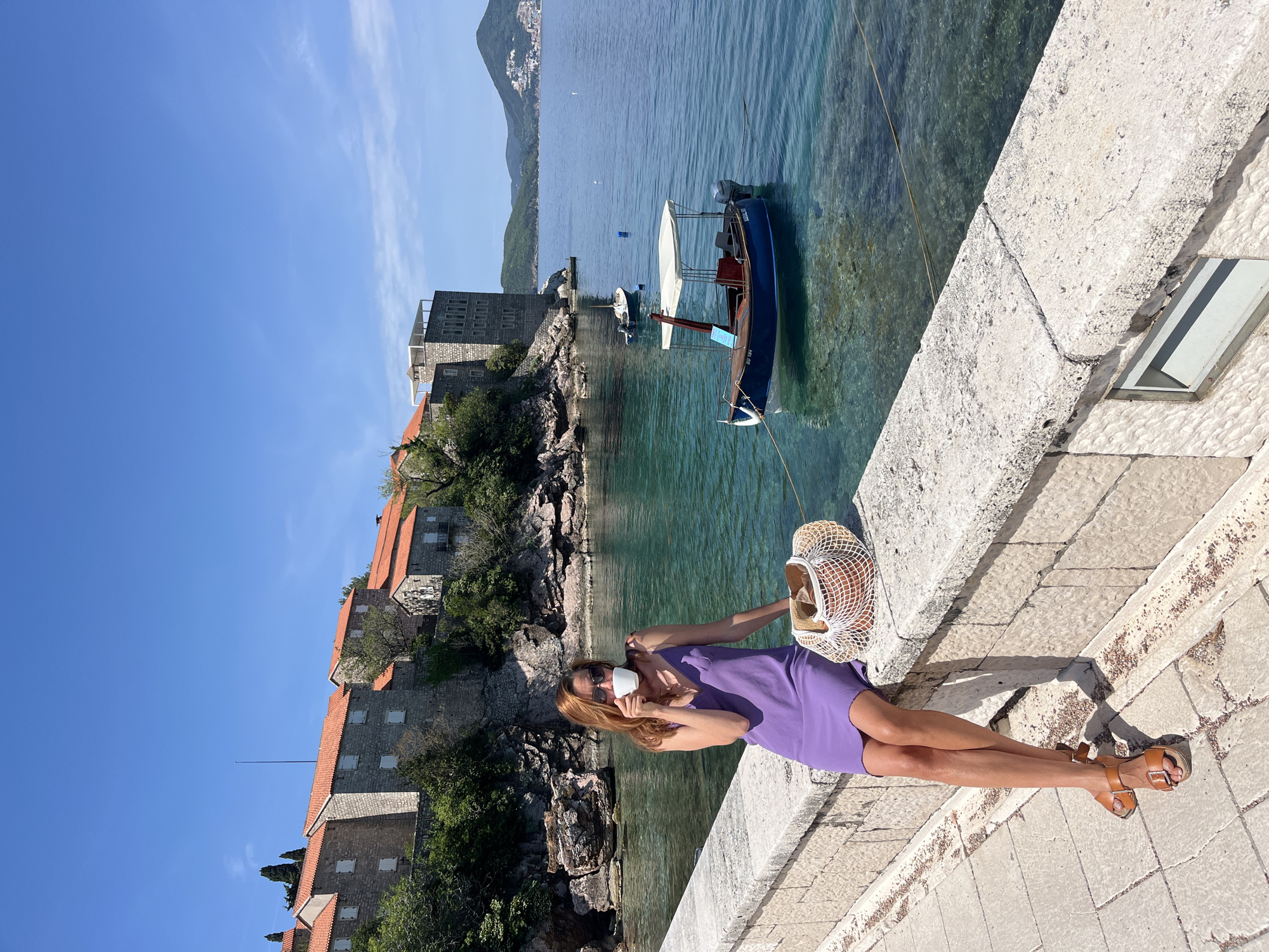 Woman enjoys sunny morning at Sveti Stefan coastal resort