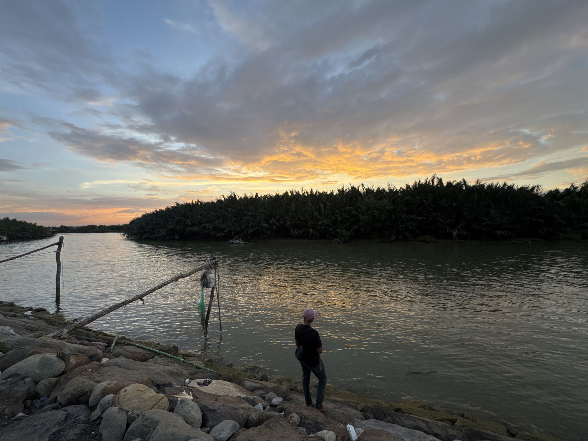 Dusk fishing on a quiet Indonesian river at sunset