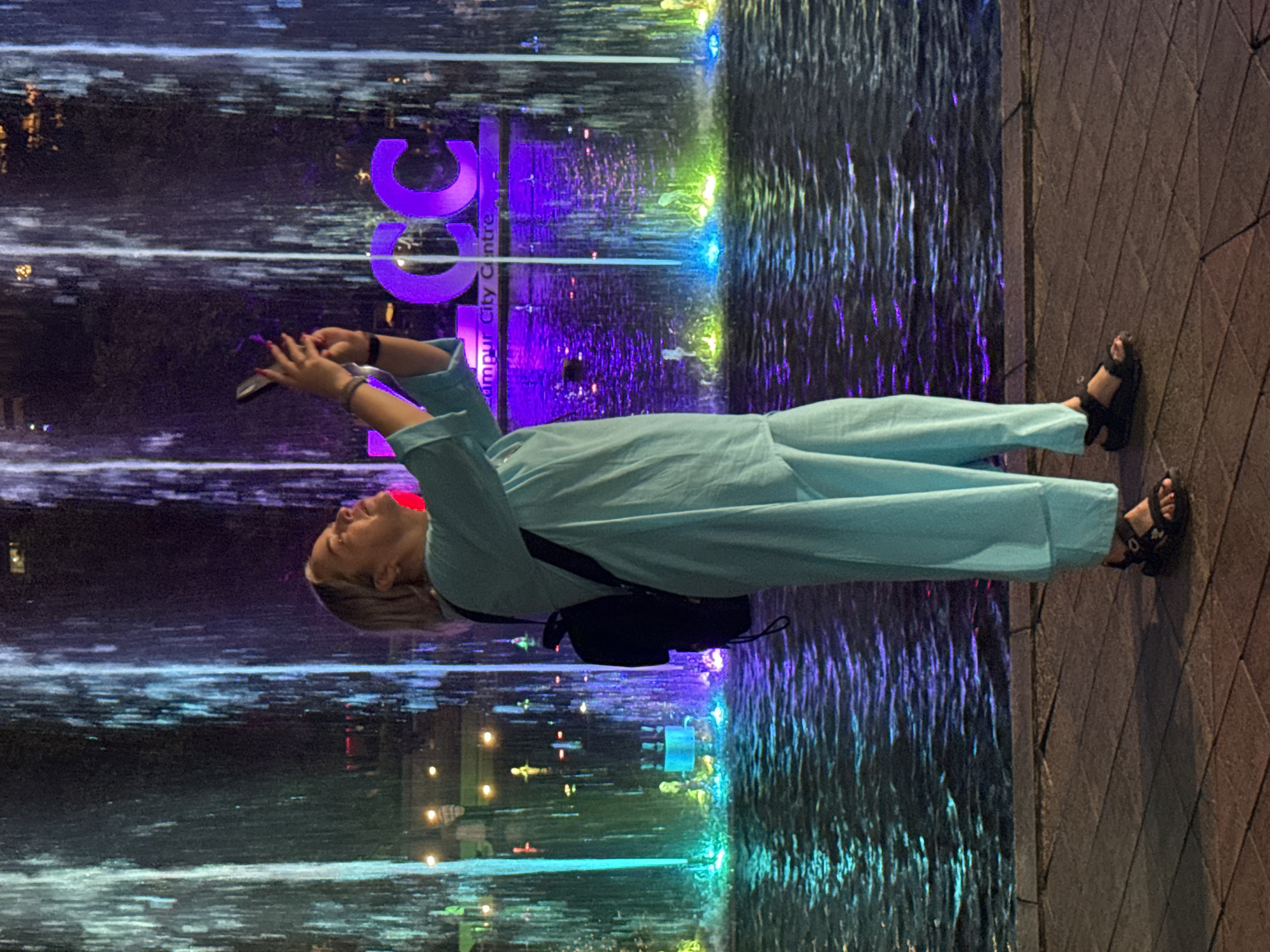 Woman photographed by illuminated water feature in Kuala Lumpur