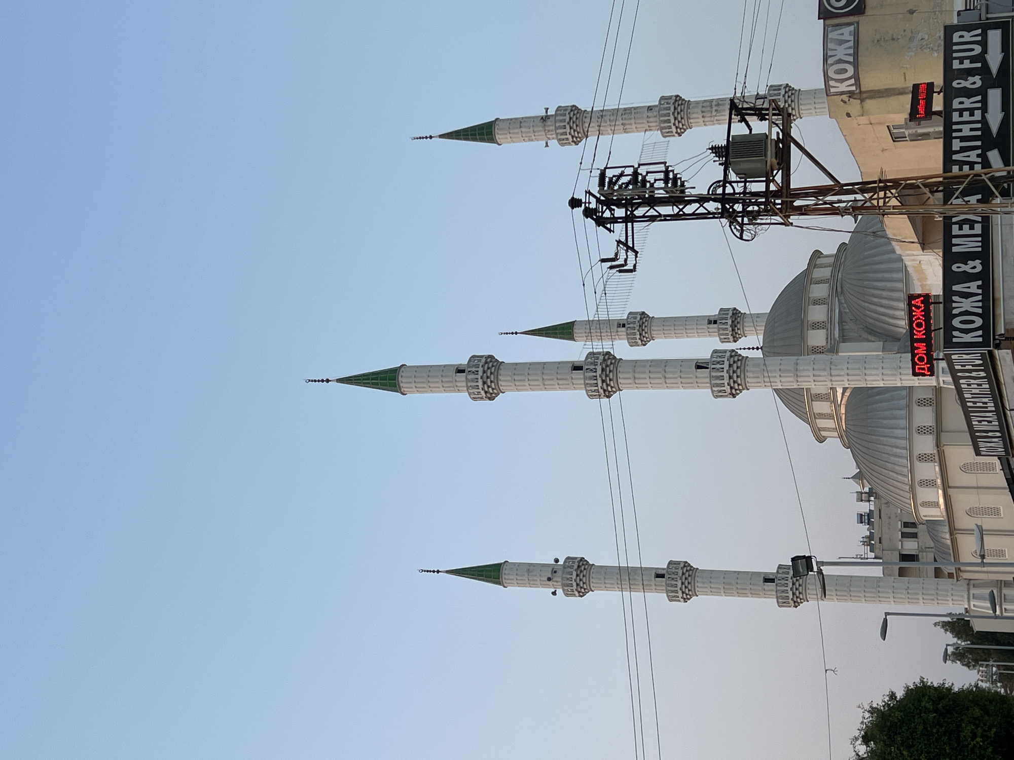 Mosque, clock tower, and market street at dusk in Central Asia