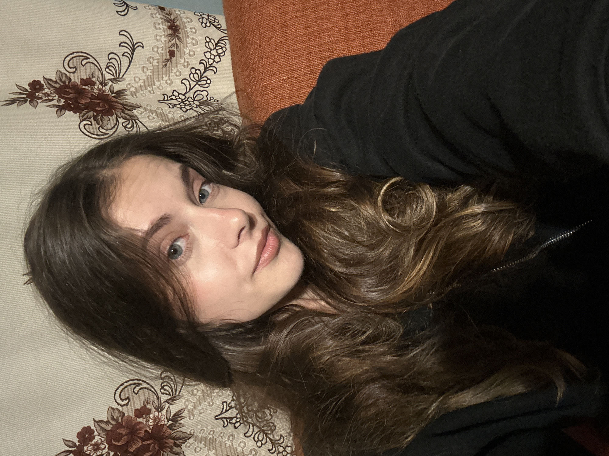Young woman takes multiple indoor selfies in unknown location