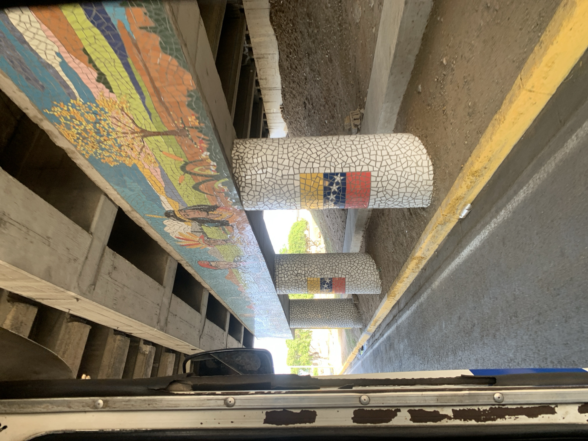 Mosaic art installation documented on Venezuelan overpass from passing vehicle