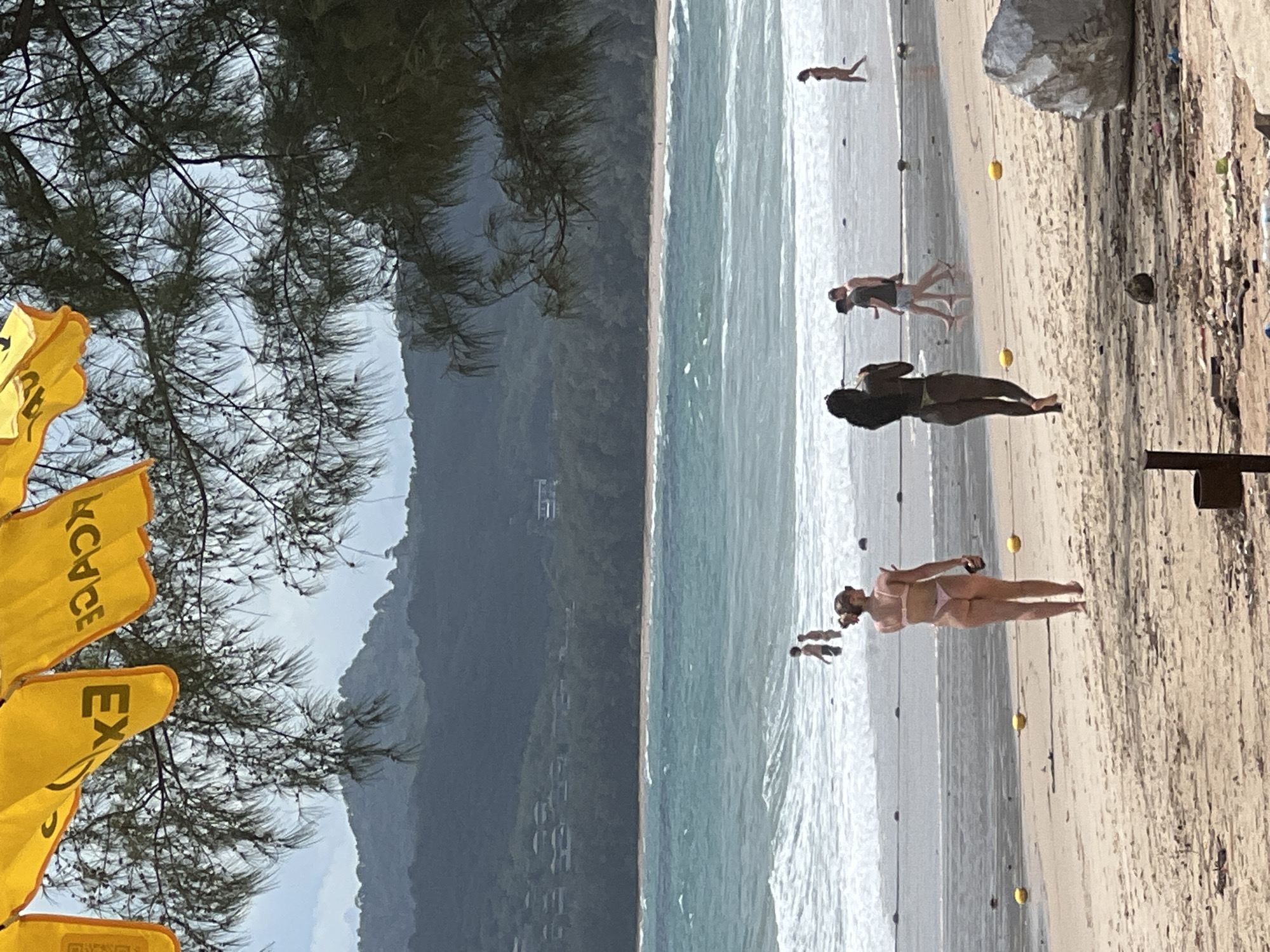Morning beach scenes show tourist area with umbrellas, flags