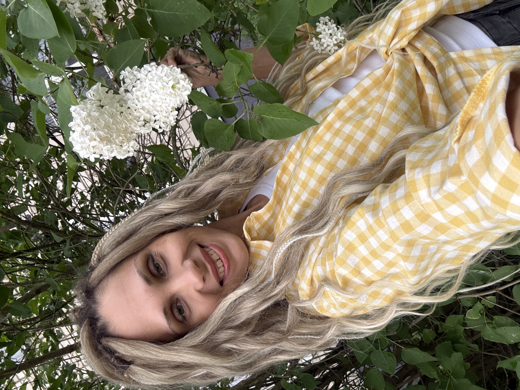 Woman photographed with flowering lilac bush in Zavolzhye, Russia