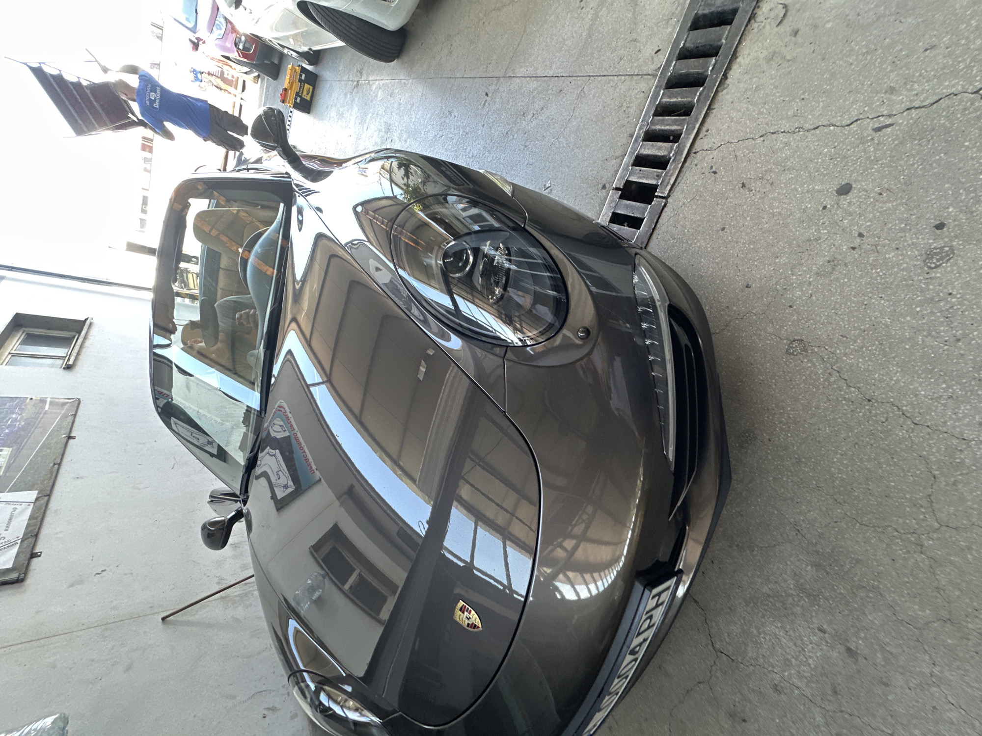 Dark gray Porsche with Bulgarian plates at an automotive facility