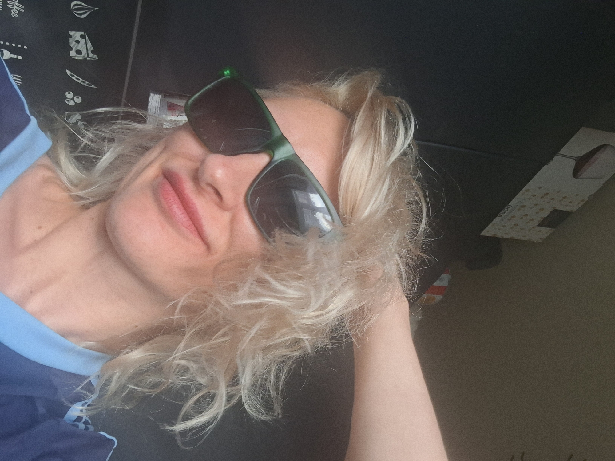 Indoor selfie series in a navy jersey and green sunglasses.