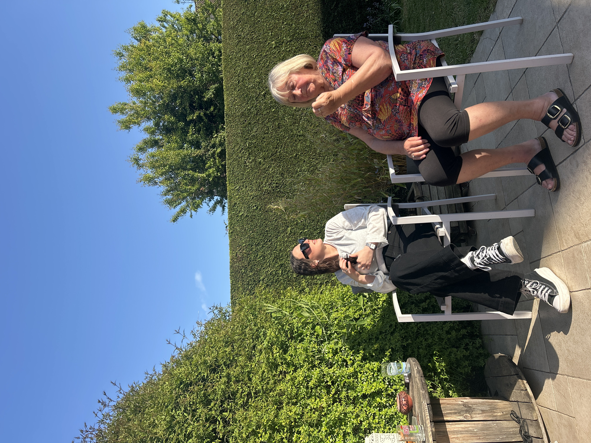Two women enjoy sunny afternoon on patio in France