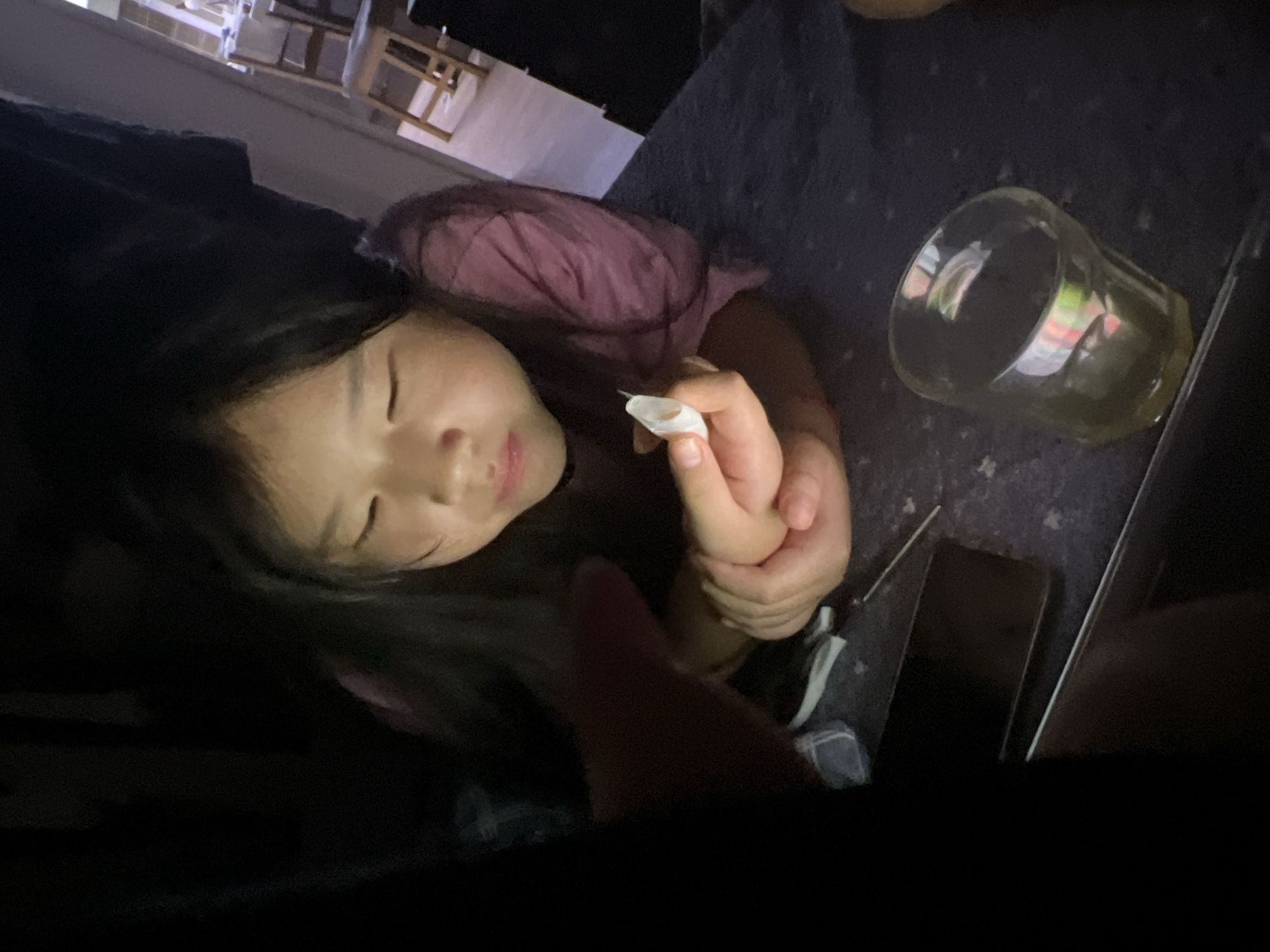 Woman with cotton swab rests on dark furniture
