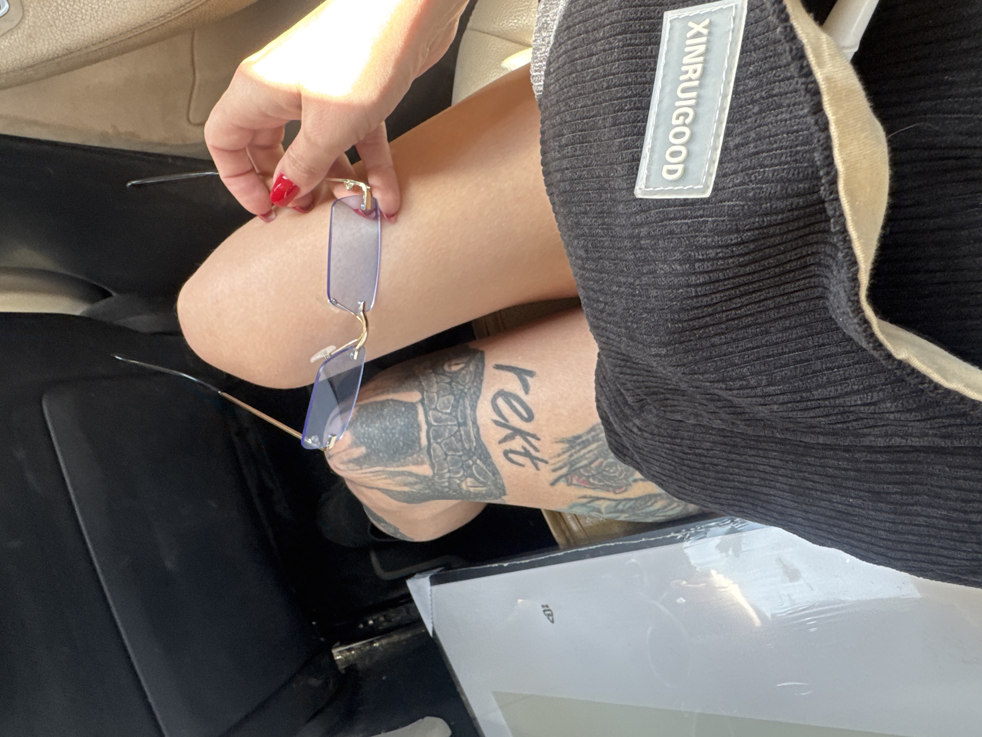 Person with red nails holds glasses in Bat Yam car