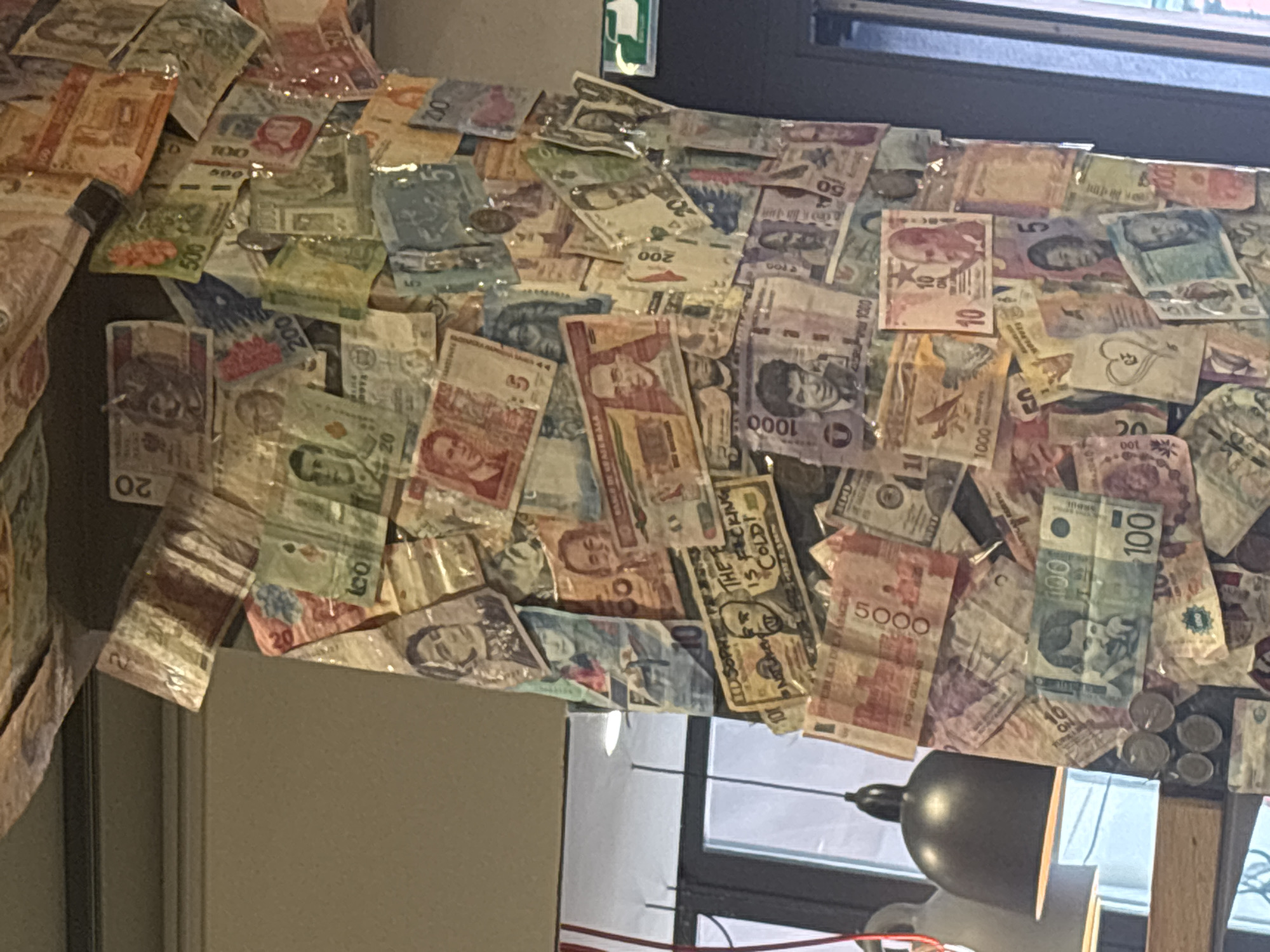 Tourist documents Swiss meal at currency-decorated Zurich restaurant