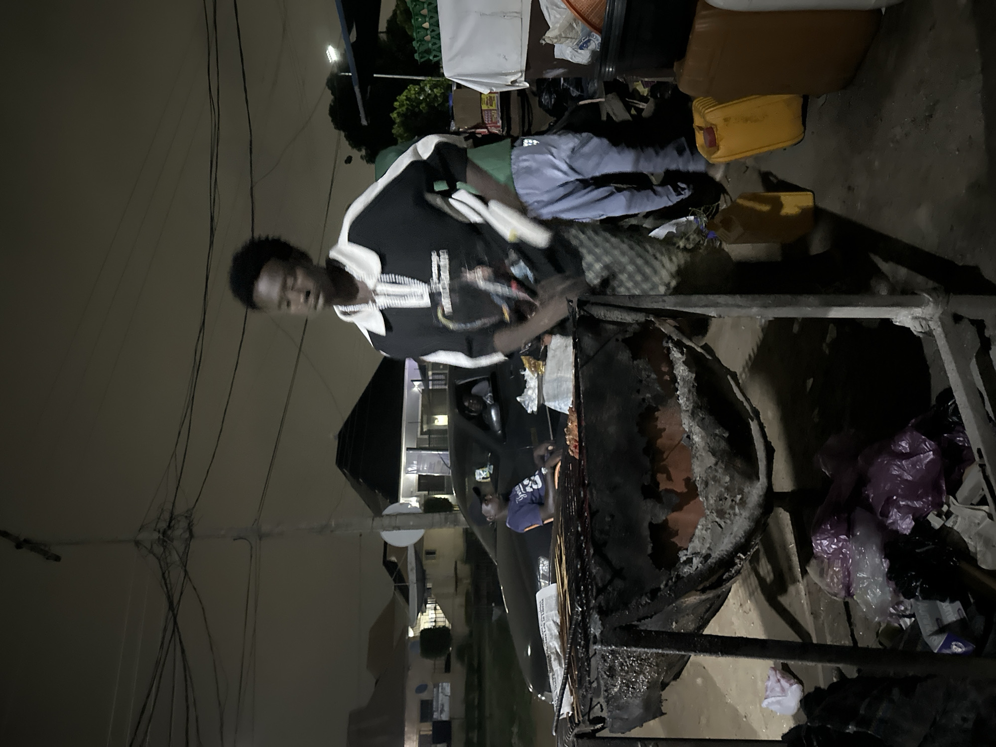 Late-night street food stall in Abuja, grills going strong