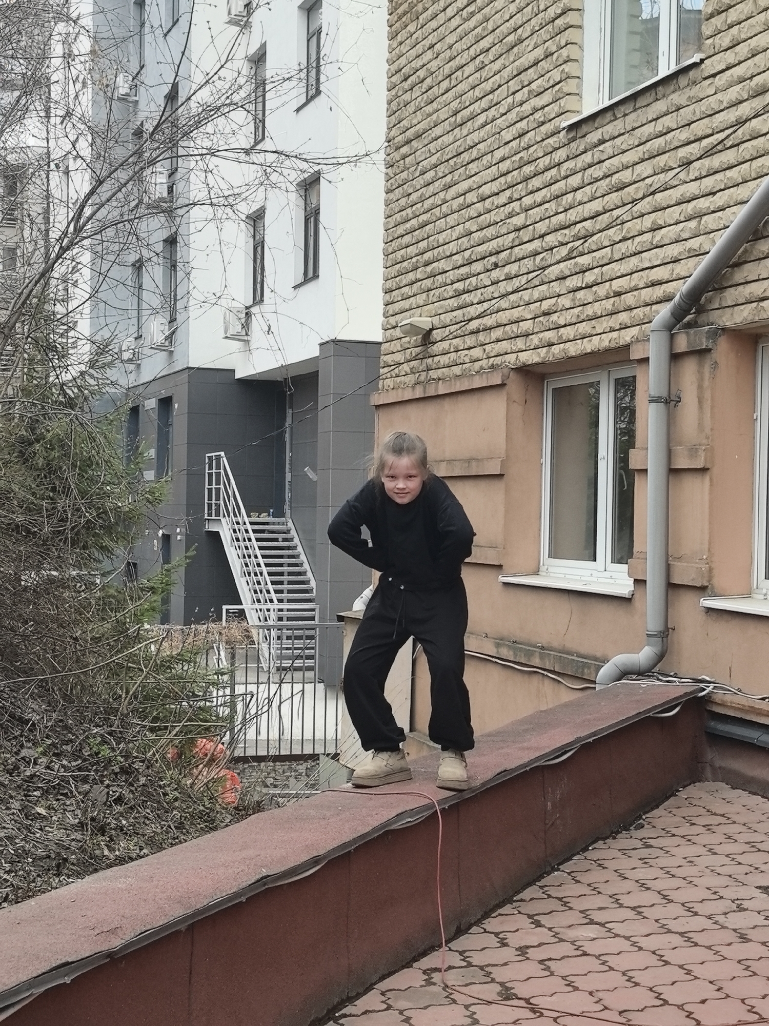 Girl stands on ledge in Nizhny Novgorod urban area