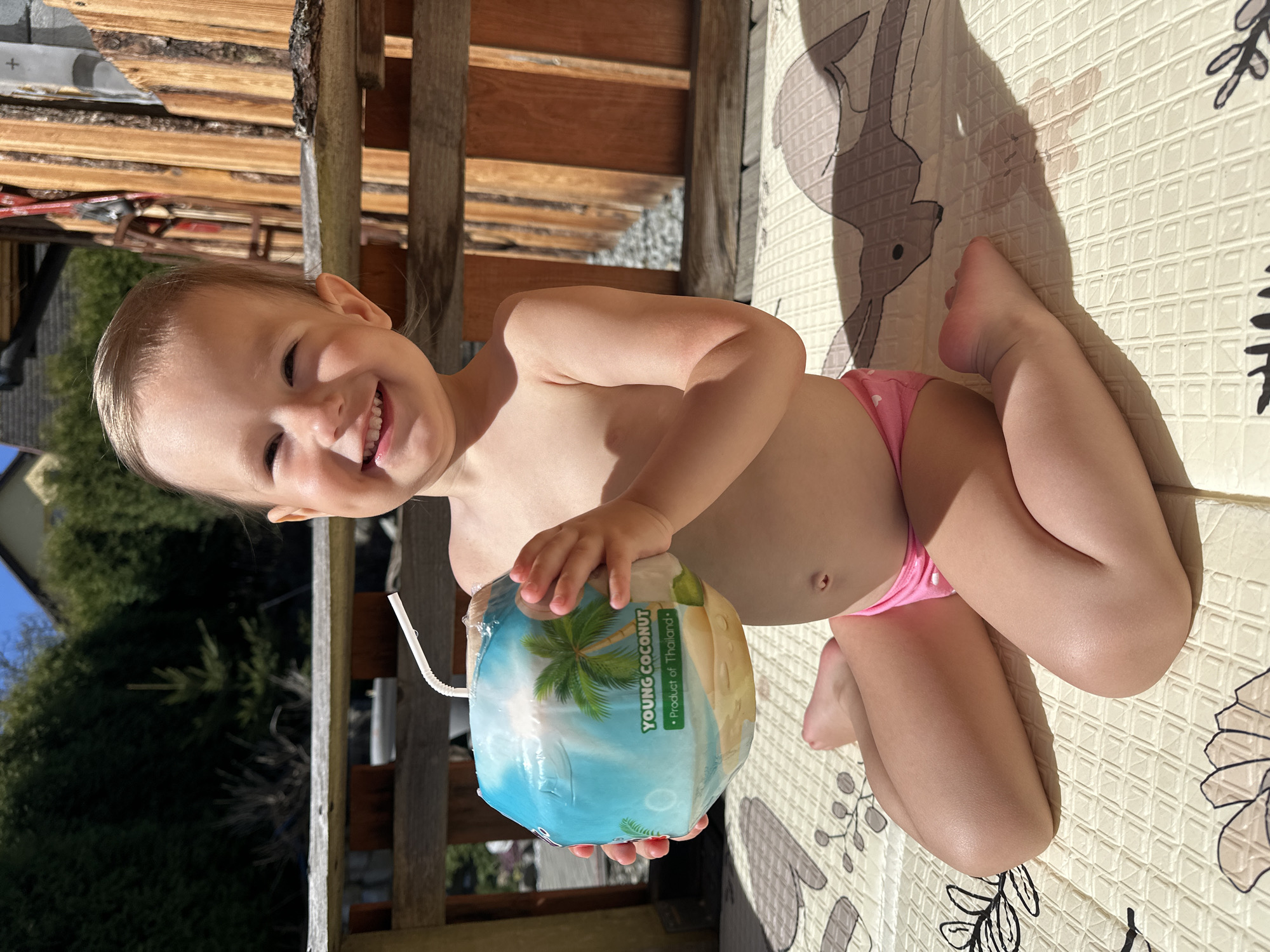Child enjoys coconut drink on outdoor deck in Wisła