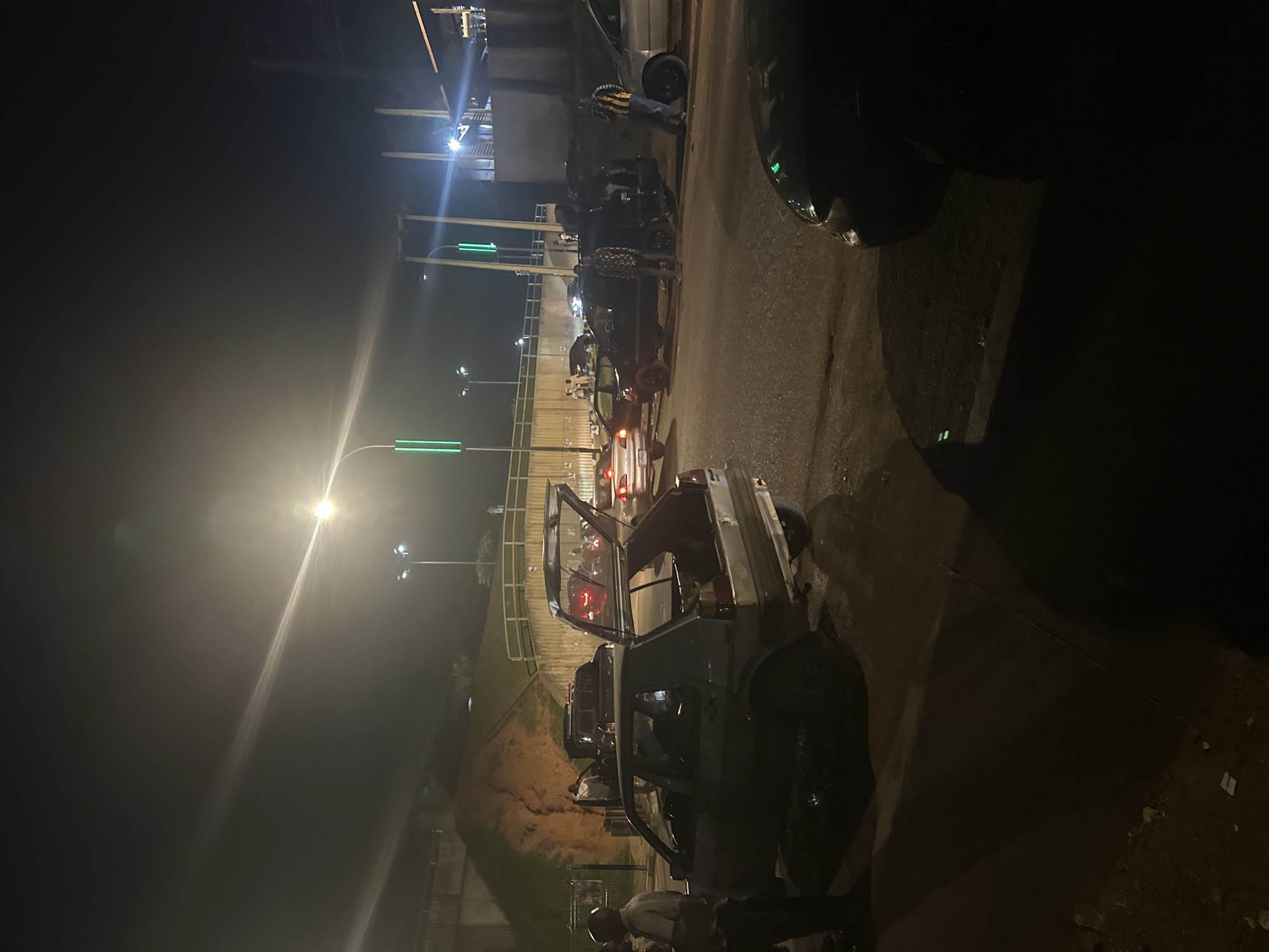 Nighttime street activity along a busy Abuja road corridor