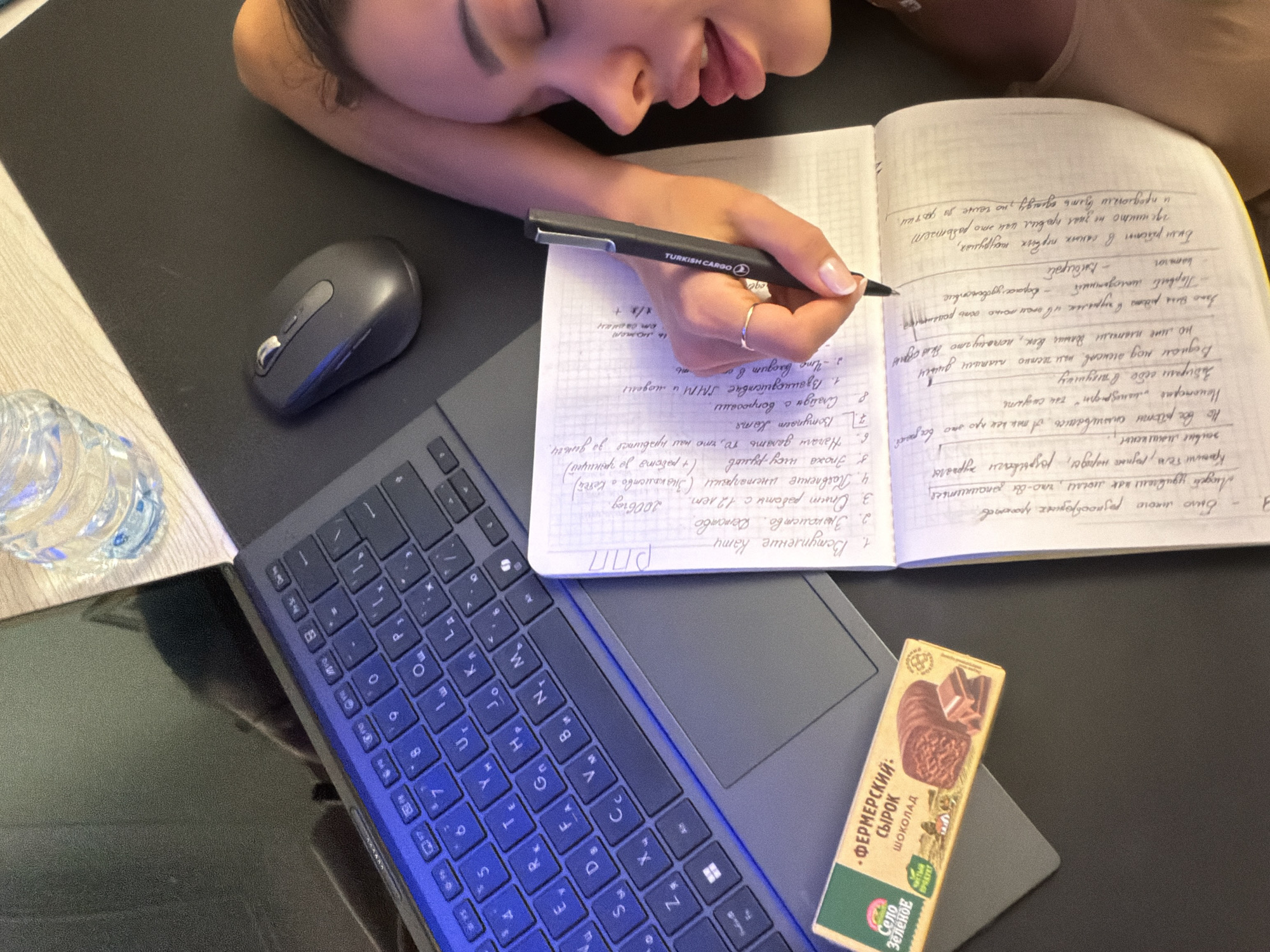 Woman writes in notebook, rests head in quiet Moscow moment