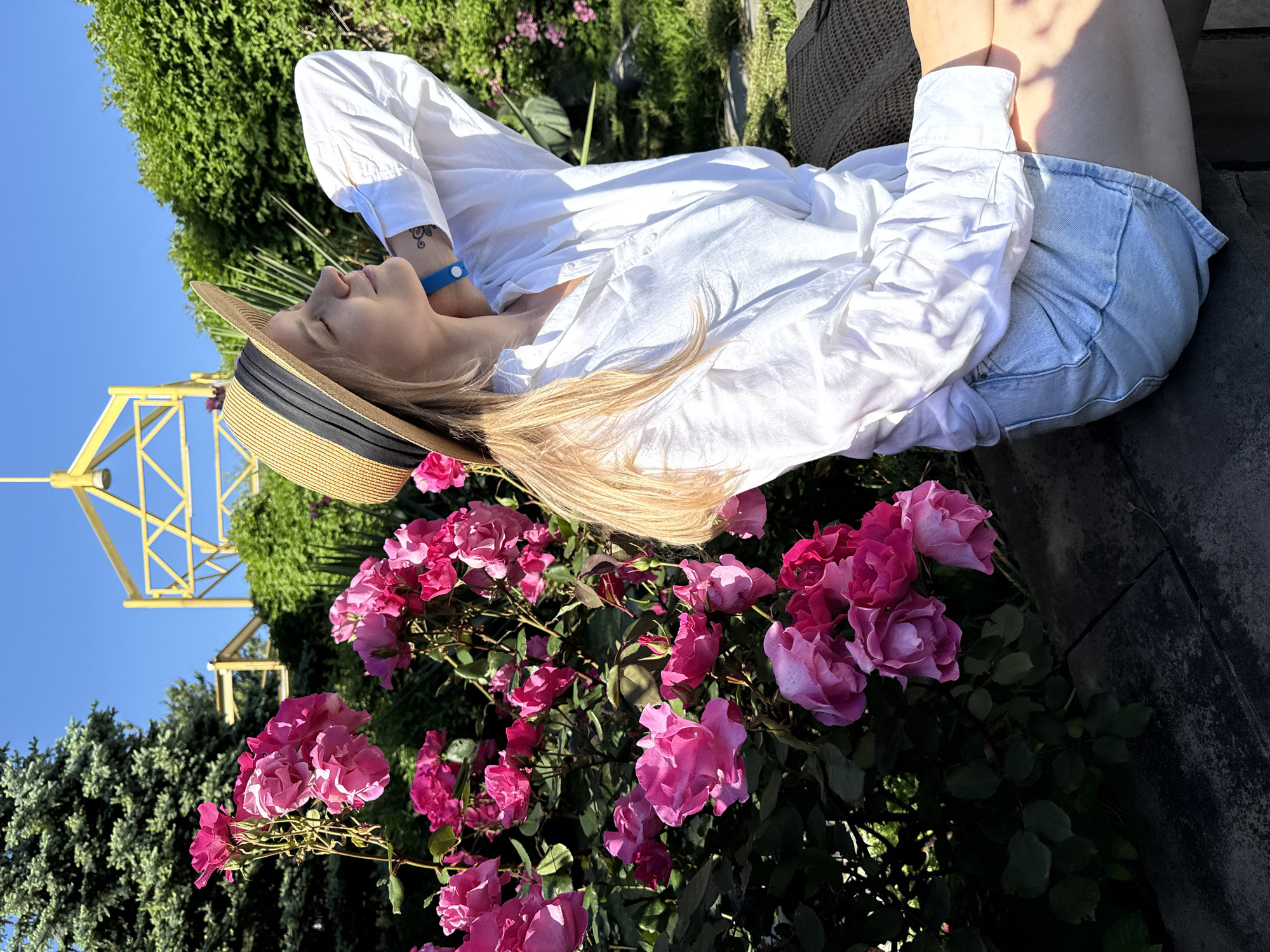 Woman enjoys sunny afternoon among roses in Nebug, Russia